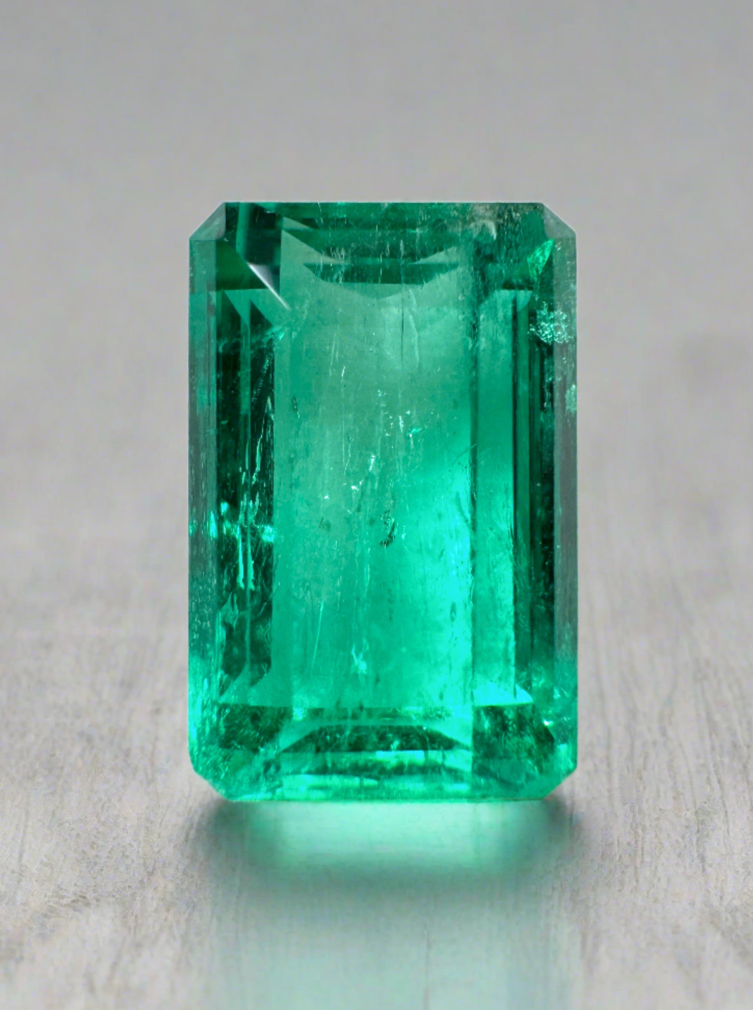 5.63 carat VS bluish green natural Colombian emerald loose gemstone in emerald cut, displayed against a neutral background.