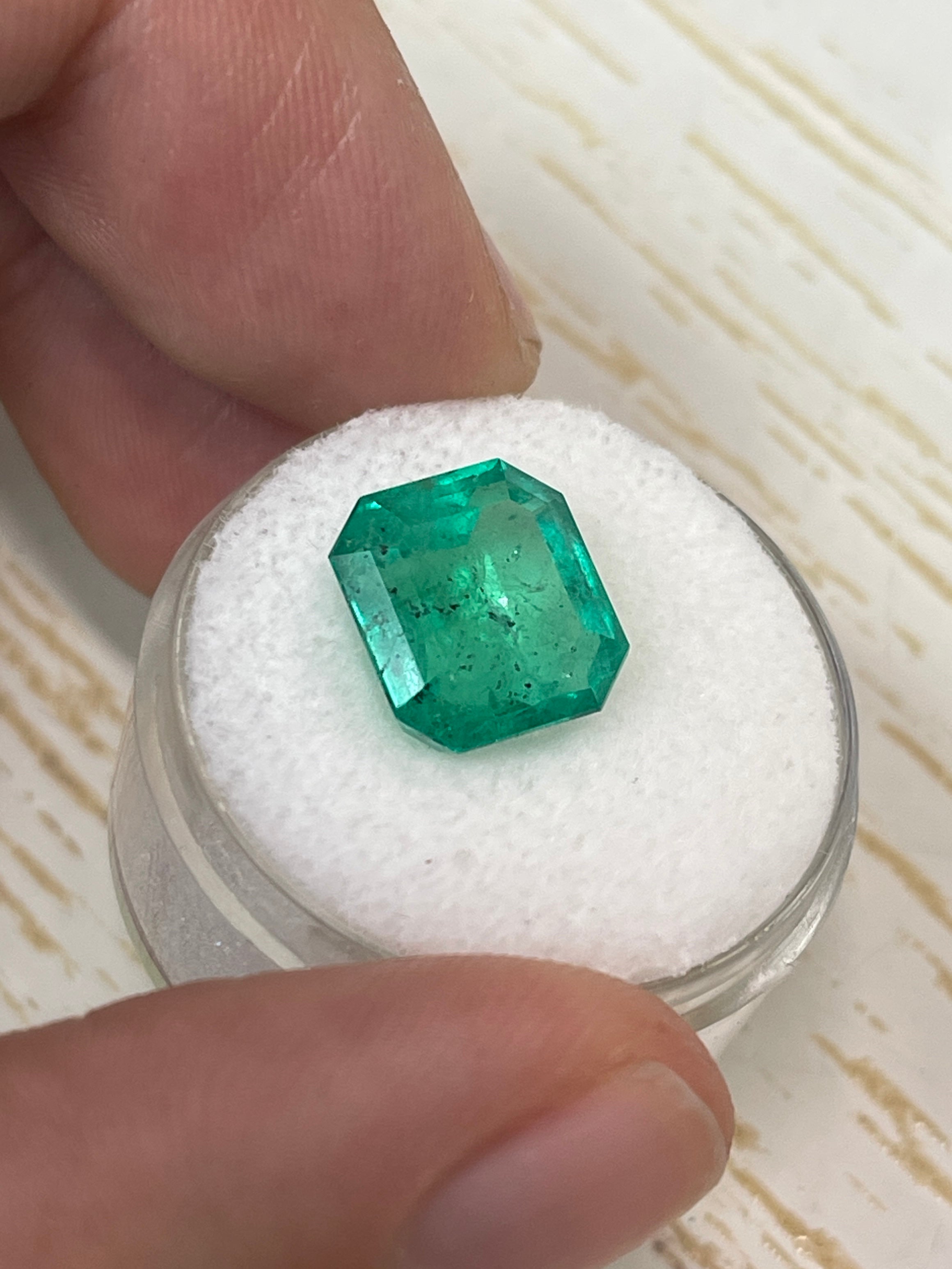 Natural 5.72 carat Colombian emerald loose gemstone with freckled forest green color in an Asscher cut, by JR Colombian Emeralds.