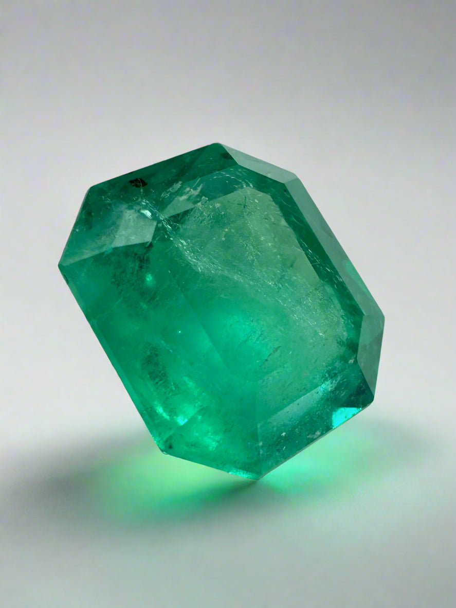 Loose 5.75 carat medium green Colombian emerald with natural freckles, emerald cut, measuring 11.5x10mm, from JR Colombian Emeralds.