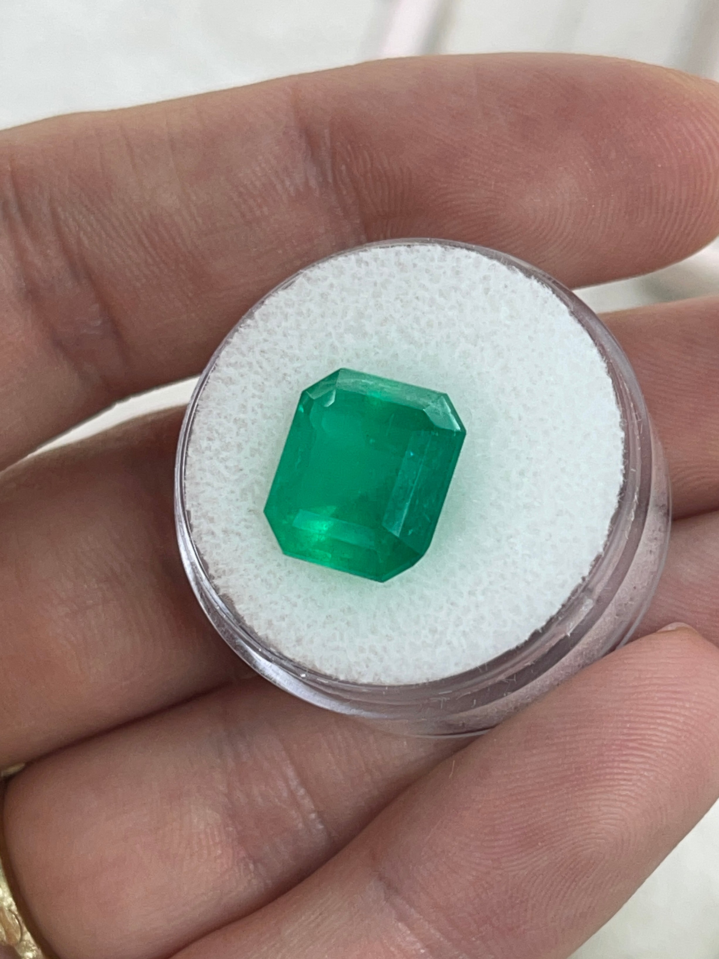 Deep green 5.94 carat natural Colombian emerald loose gemstone in emerald cut, showcasing vibrant color and clarity.