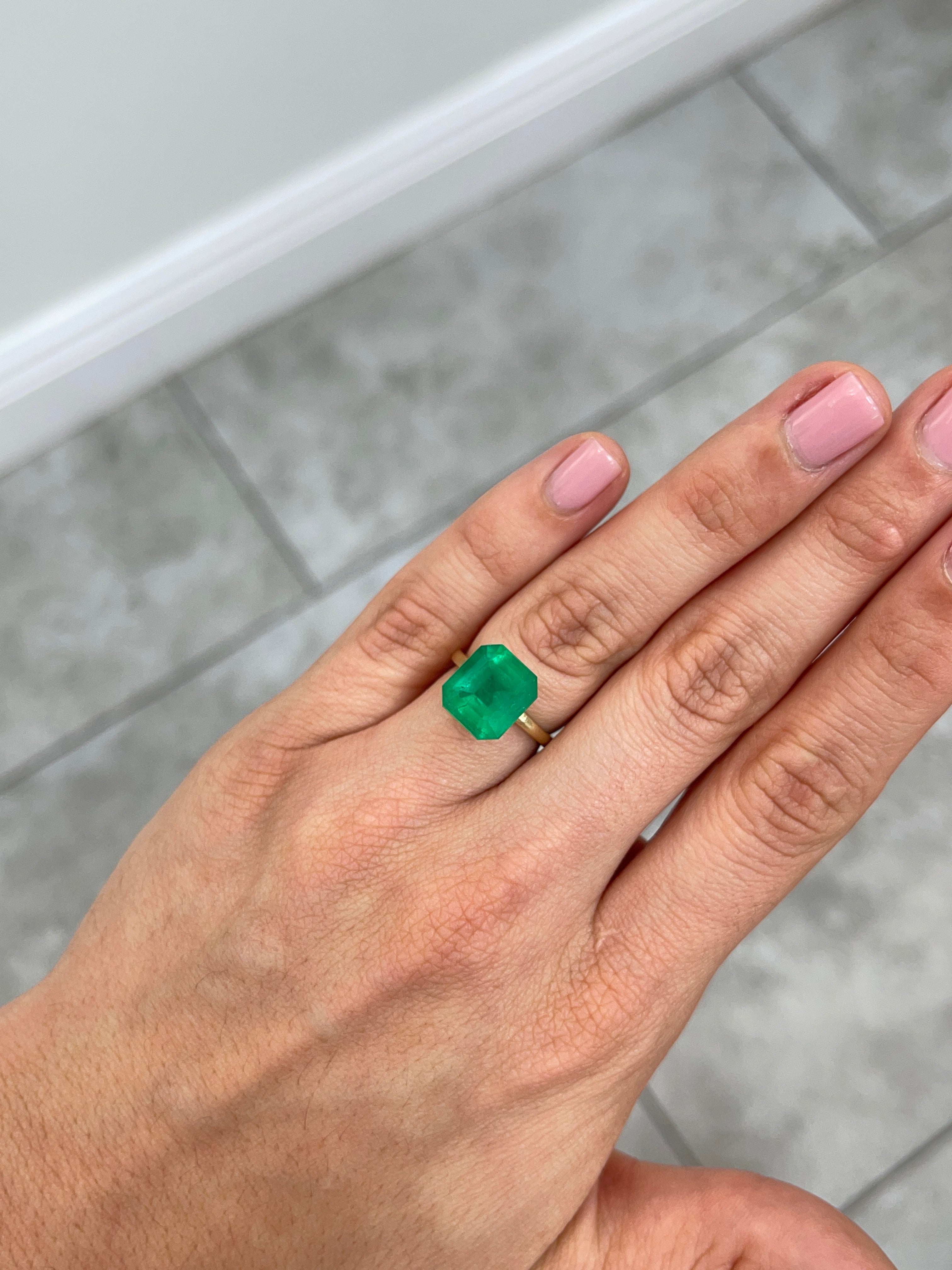 Deep green 5.94 carat natural Colombian emerald loose gemstone in an emerald cut, showcasing vibrant color and clarity.