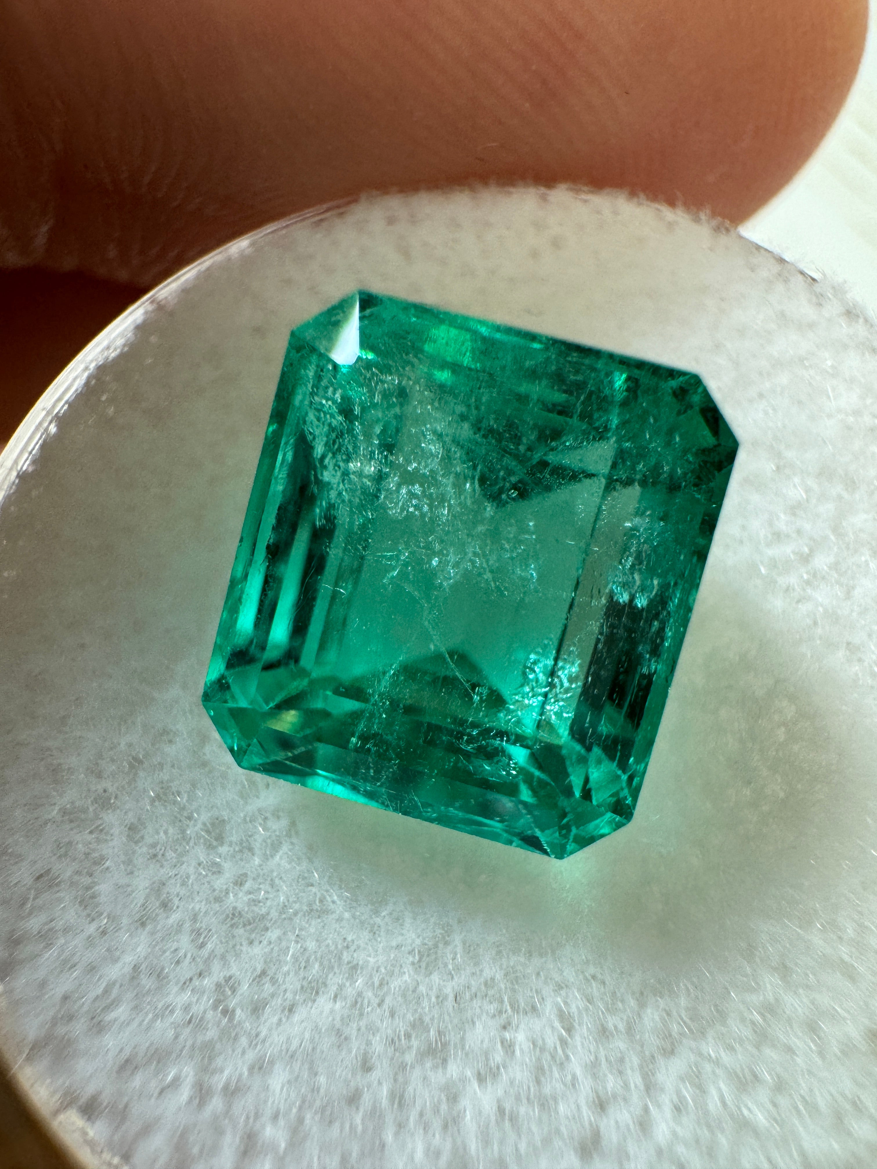 Loose 5.98 carat Colombian emerald in 10x9 emerald cut with crystal-clear green color, natural and unmounted.