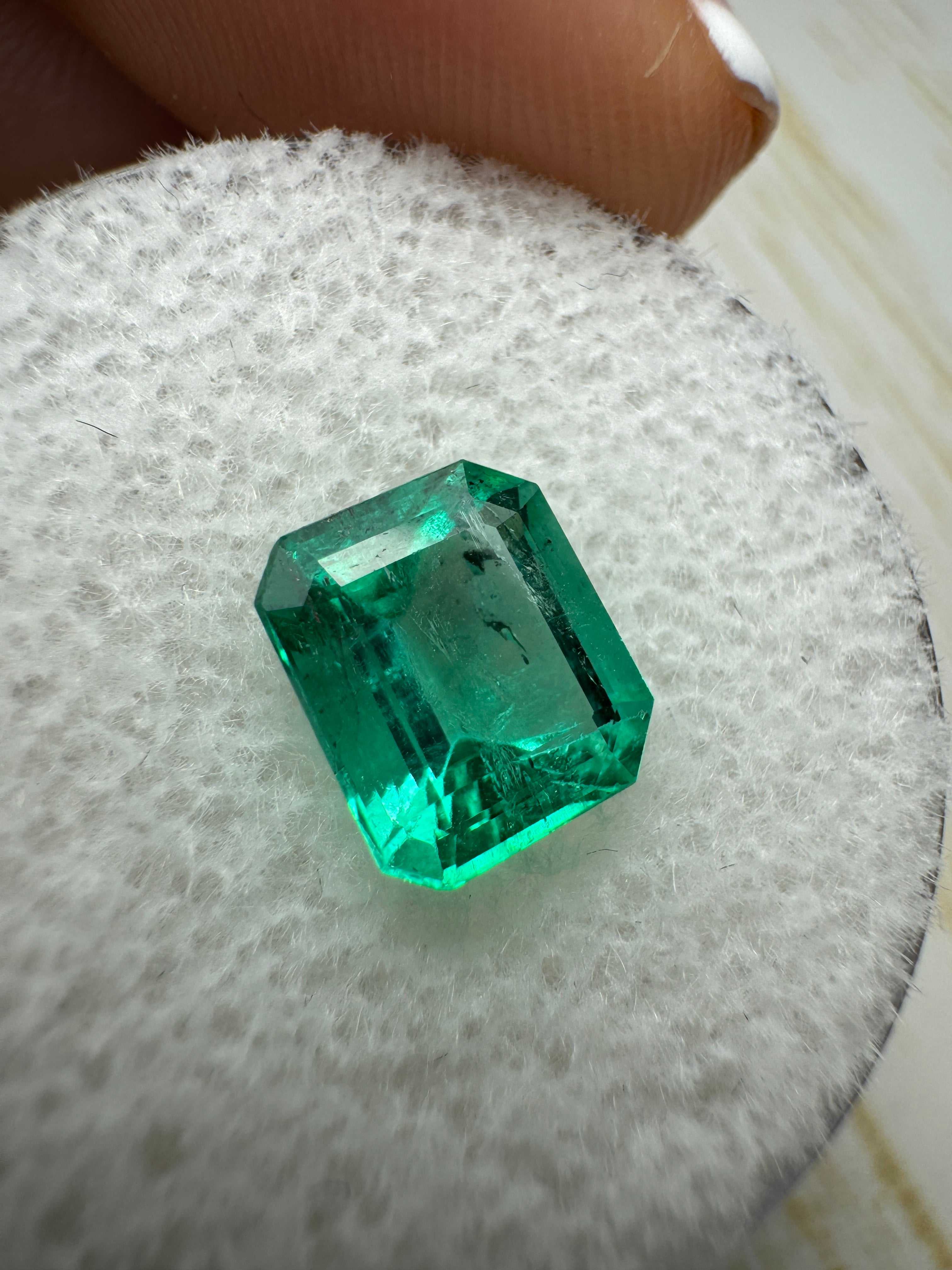 1.69 Carat bright bluish green Colombian emerald loose gemstone in emerald cut, showcased by JR Colombian Emeralds.