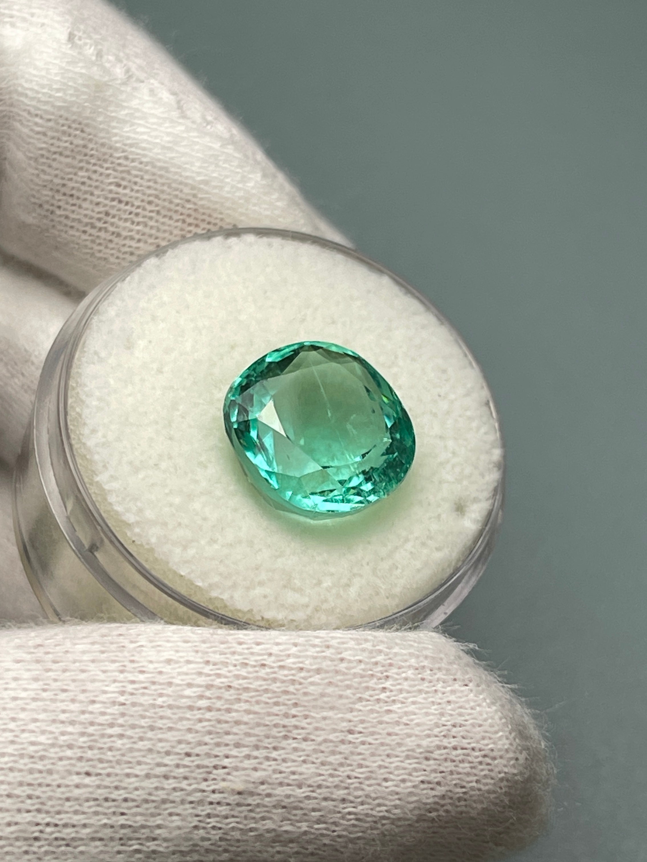 Luminous bluish green 6.38 carat natural Colombian emerald in cushion cut, loose gemstone with vibrant color and clarity.
