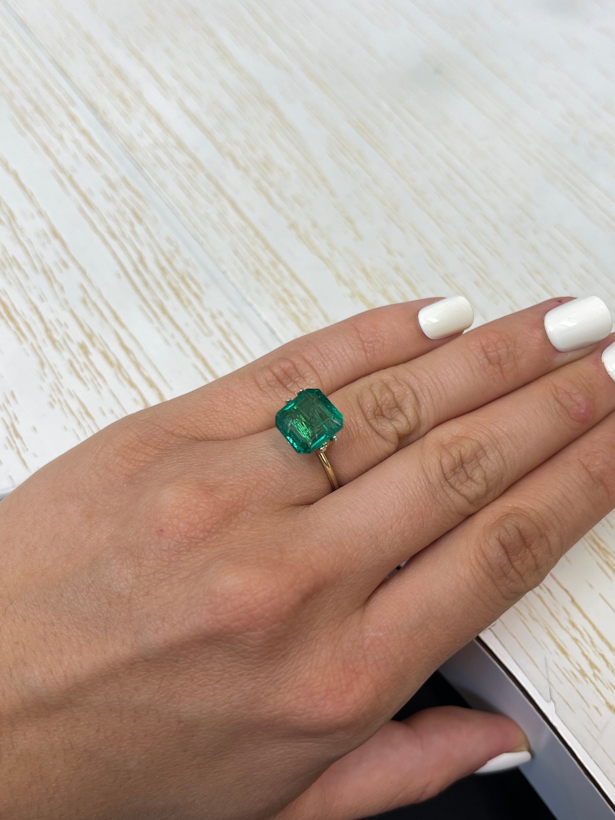 Medium deep green Zambian emerald cut loose gemstone, 6.54 carats, from JR Colombian Emeralds, showing clarity and vibrant color.