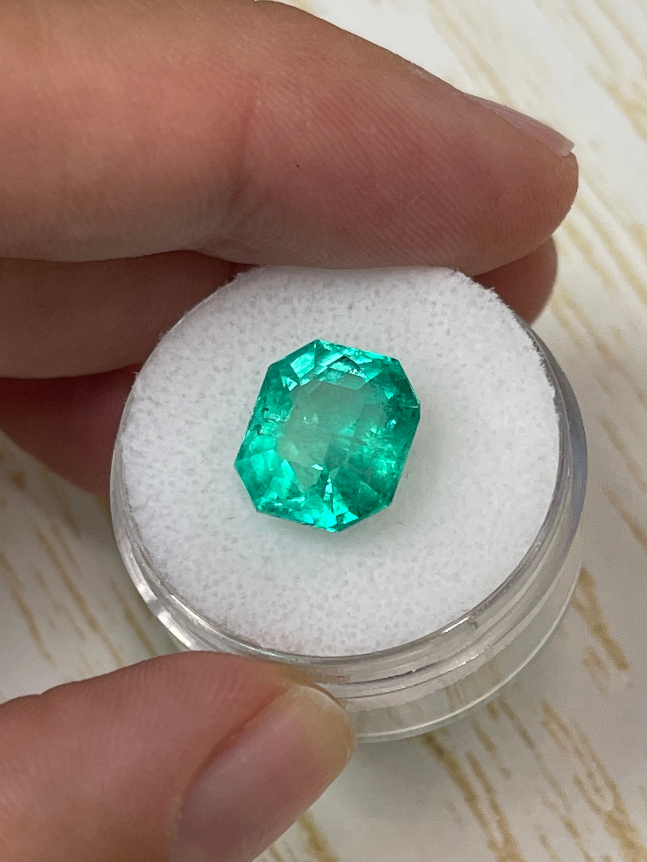 6.63 carat natural Colombian emerald in an 11x10mm chunky emerald cut, showcasing vibrant green color and clarity.