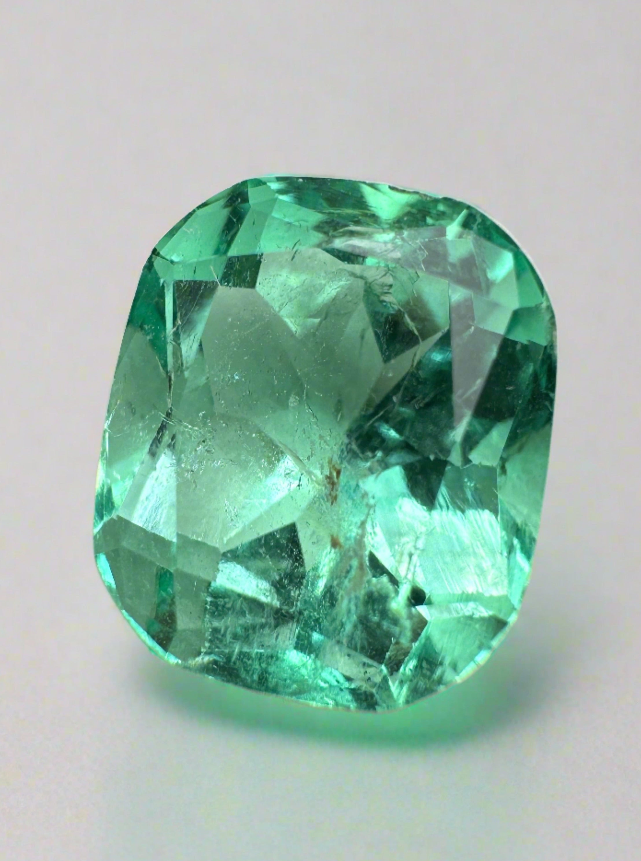 7.13 carat bluish green Colombian emerald loose cushion cut gemstone from JR Colombian Emeralds. Natural, vibrant, and faceted.