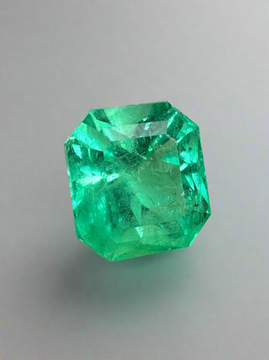 7.76-carat yellowish green natural Colombian emerald loose gemstone in an Asscher cut, displayed on a jewelry stand.