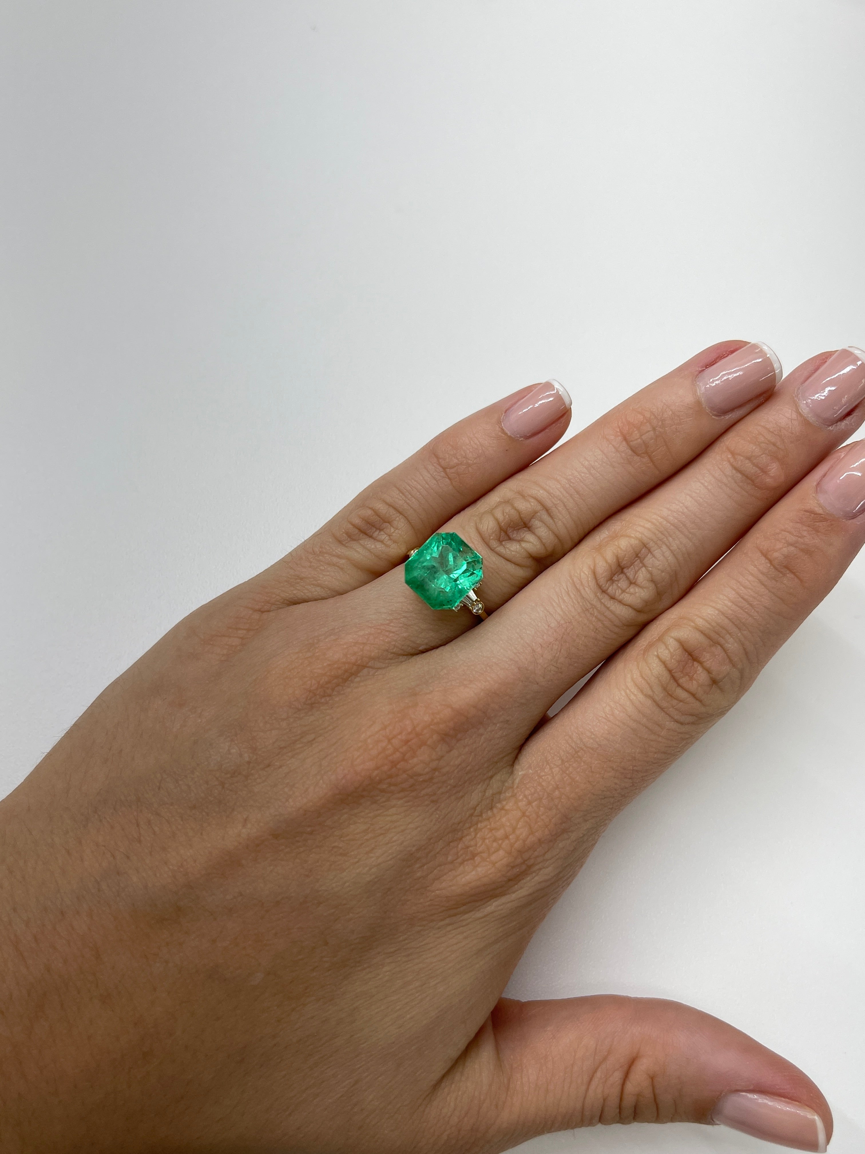 7.76 carat yellowish green natural Colombian emerald loose Asscher cut, showcasing vibrant color and clarity.