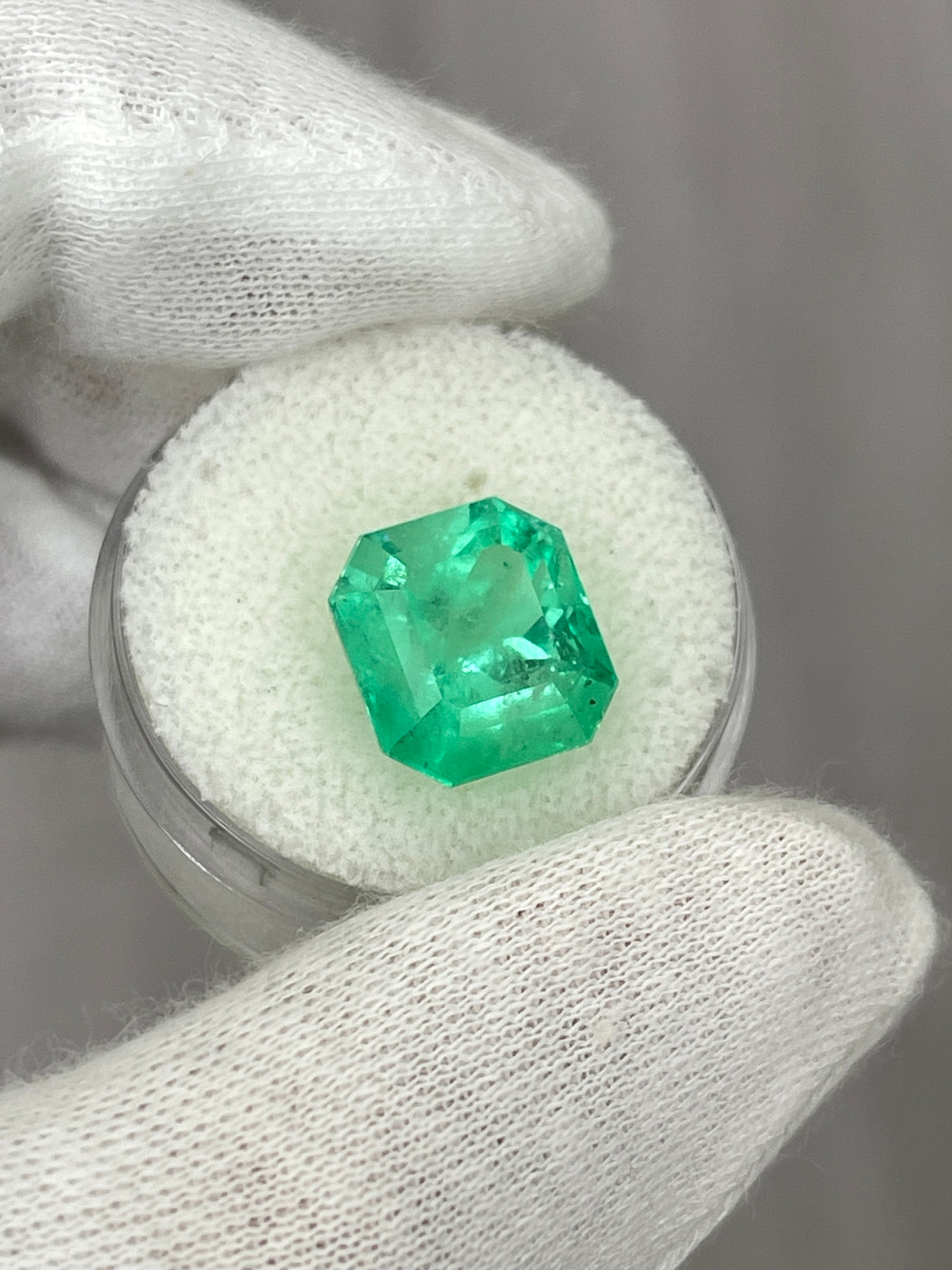 7.76-carat yellowish green natural Colombian emerald loose Asscher cut gemstone, showcasing its vibrant color and rectangular shape.