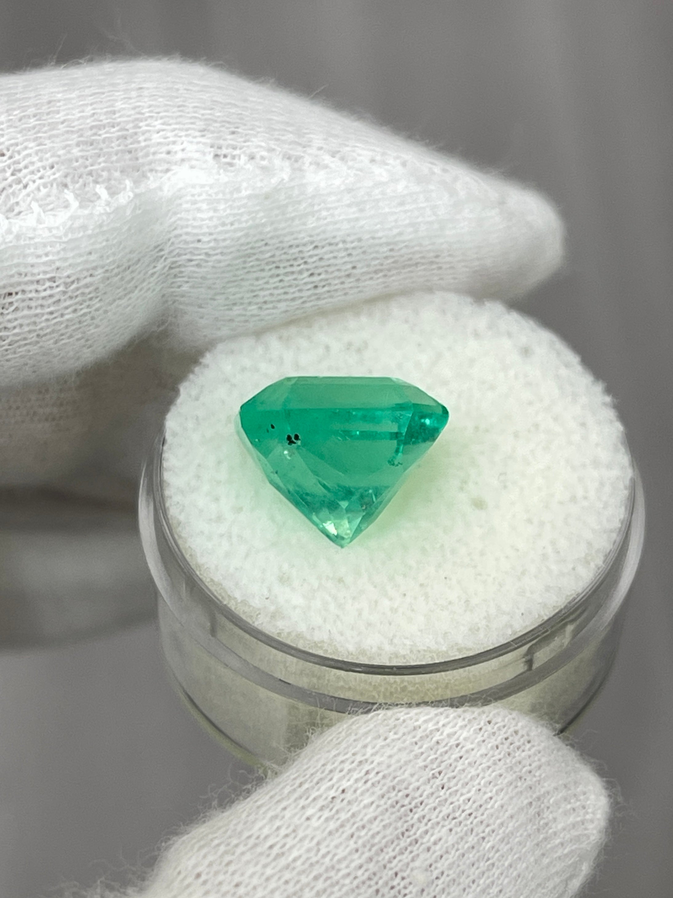 7.76 carat yellowish green natural Colombian emerald loose Asscher cut gemstone with precise facets and vibrant color.