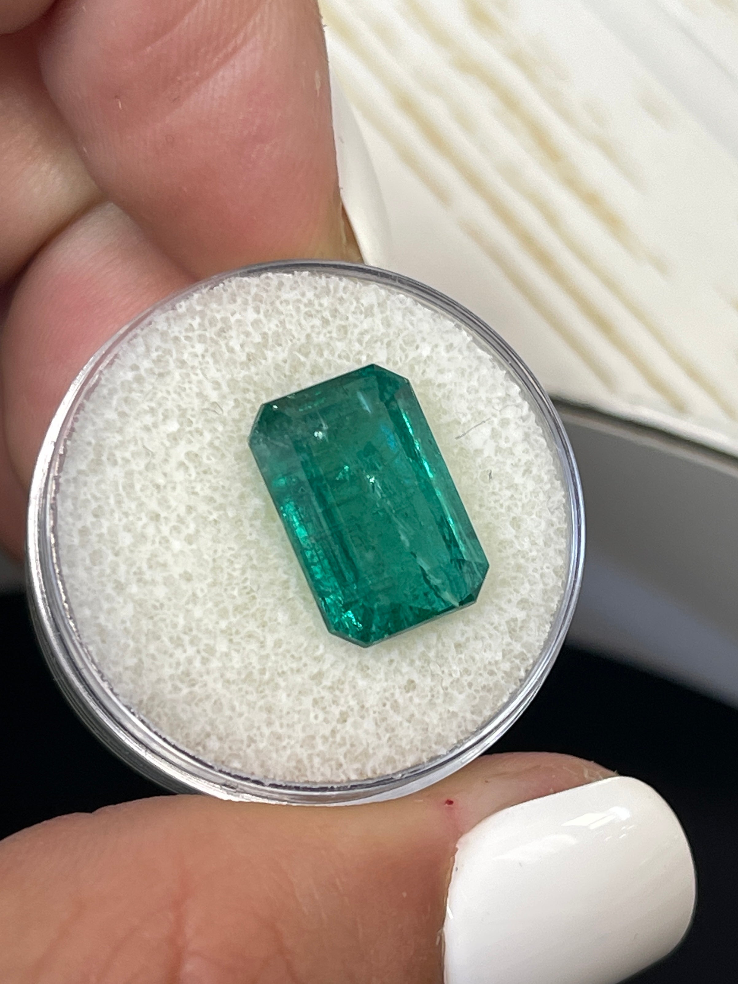 7.96 carat elongated green Zambian emerald cut loose gemstone from JR Colombian Emeralds, natural and vibrant with clarity.