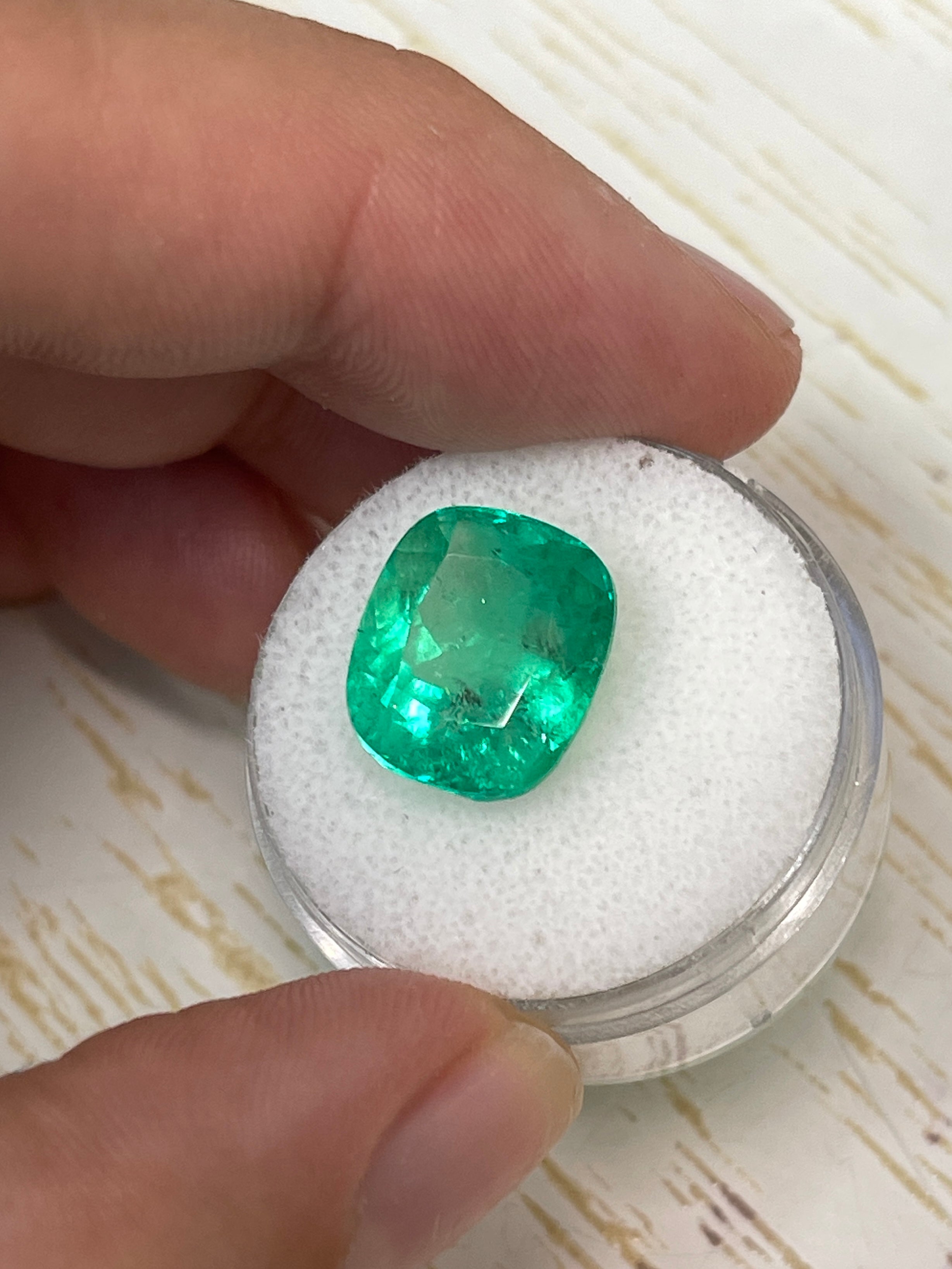 8.04 carat yellowish green natural Colombian emerald loose cushion cut gemstone with vibrant color and clarity.