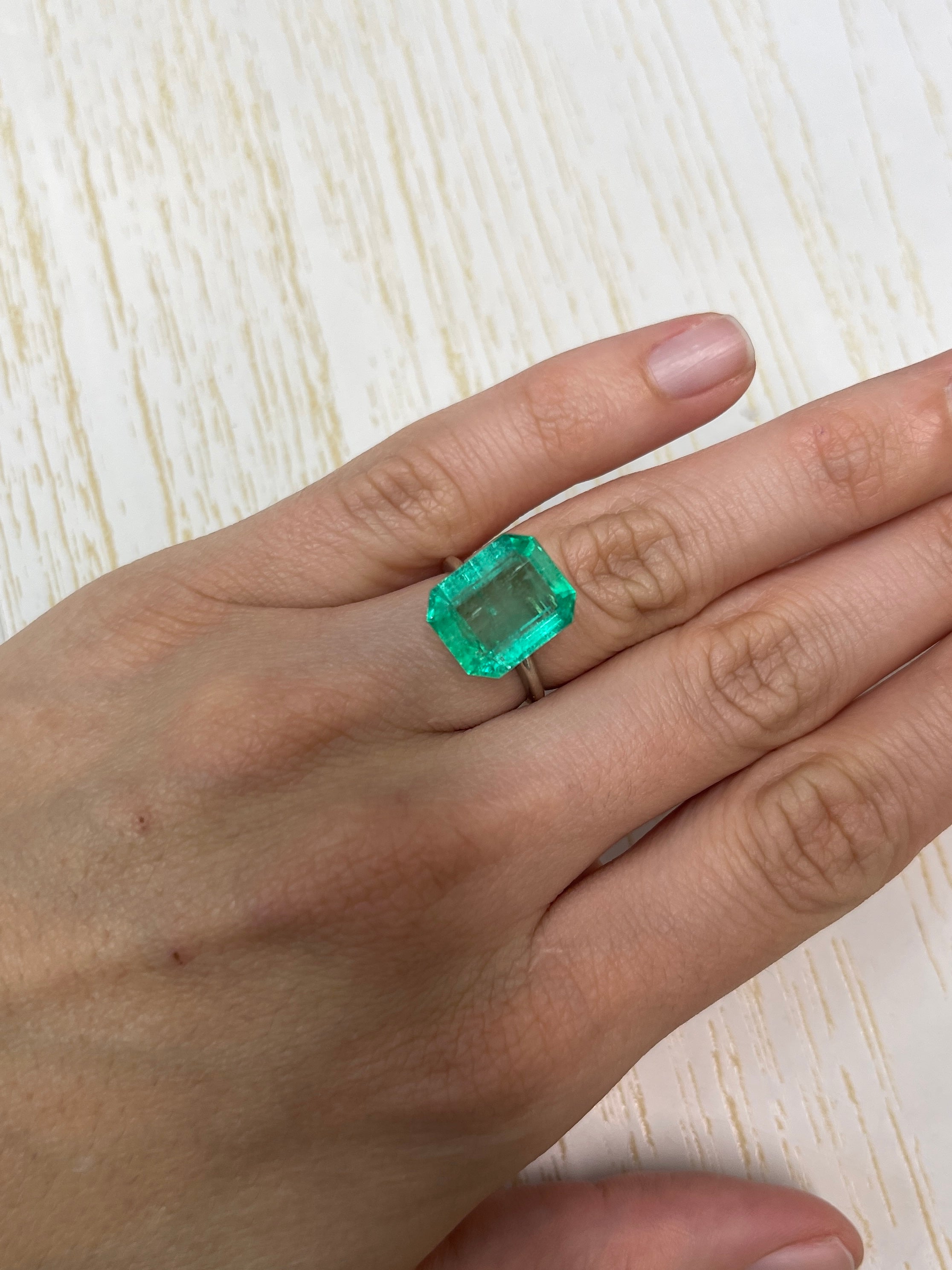 8.20 carat medium green Colombian emerald cut loose gemstone with emerald cut, showcasing vibrant green color and clarity.