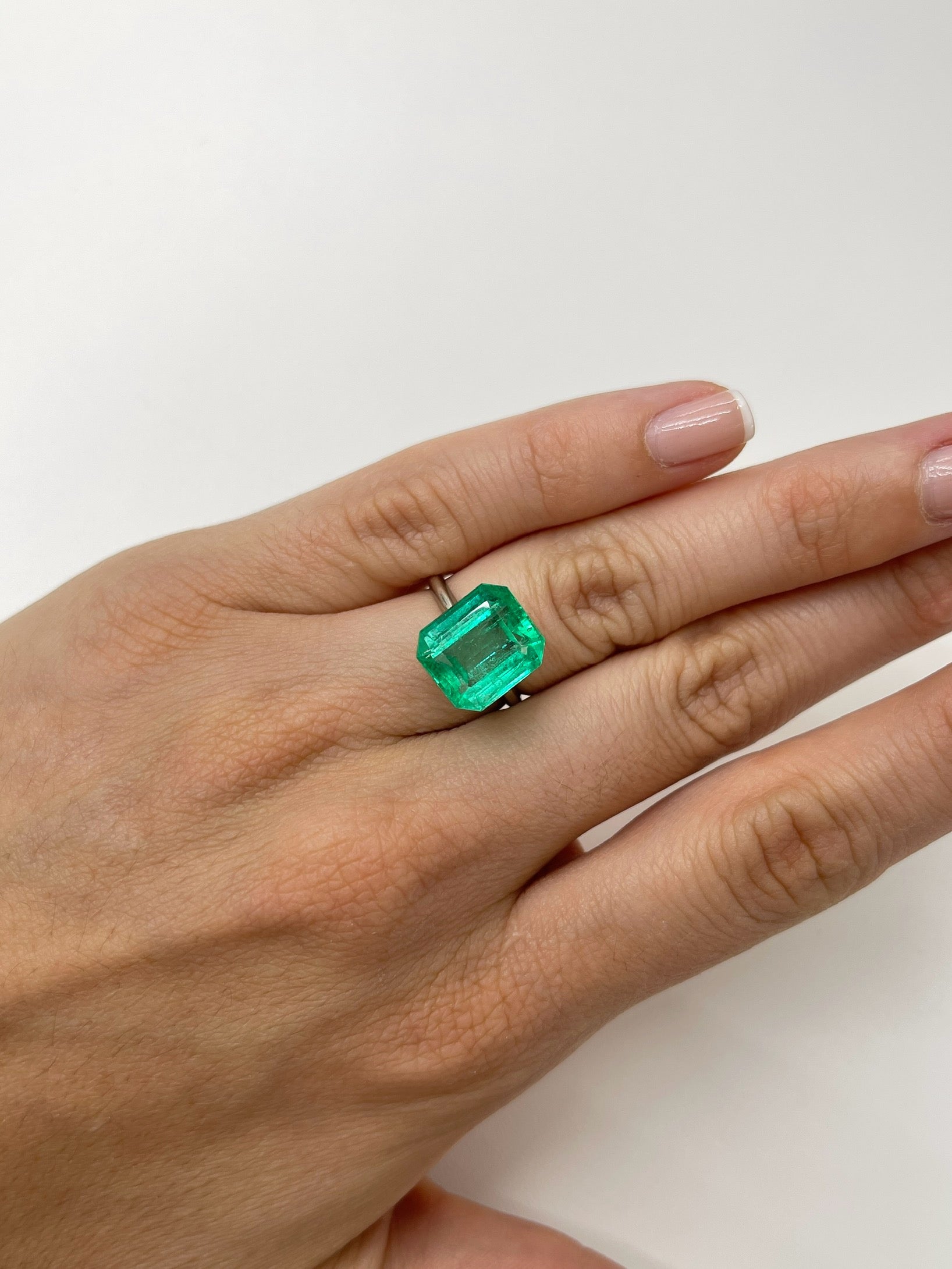 8.33 carat Colombian emerald cut loose gemstone with crystal-clear clarity, showcasing the vibrant green color and precise cut.