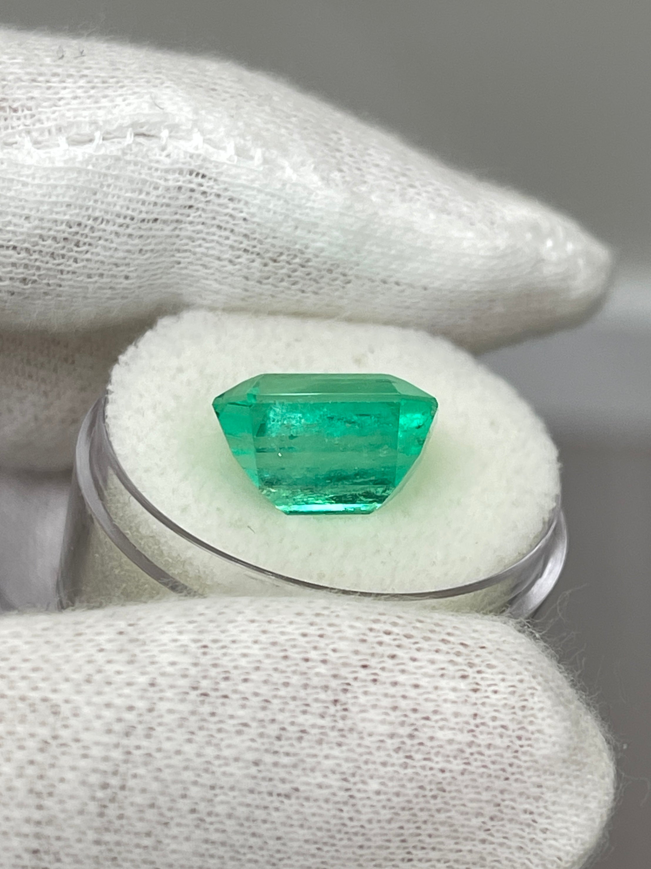 8.33 carat Colombian emerald cut loose gemstone with crystal-clear clarity and vibrant green color.