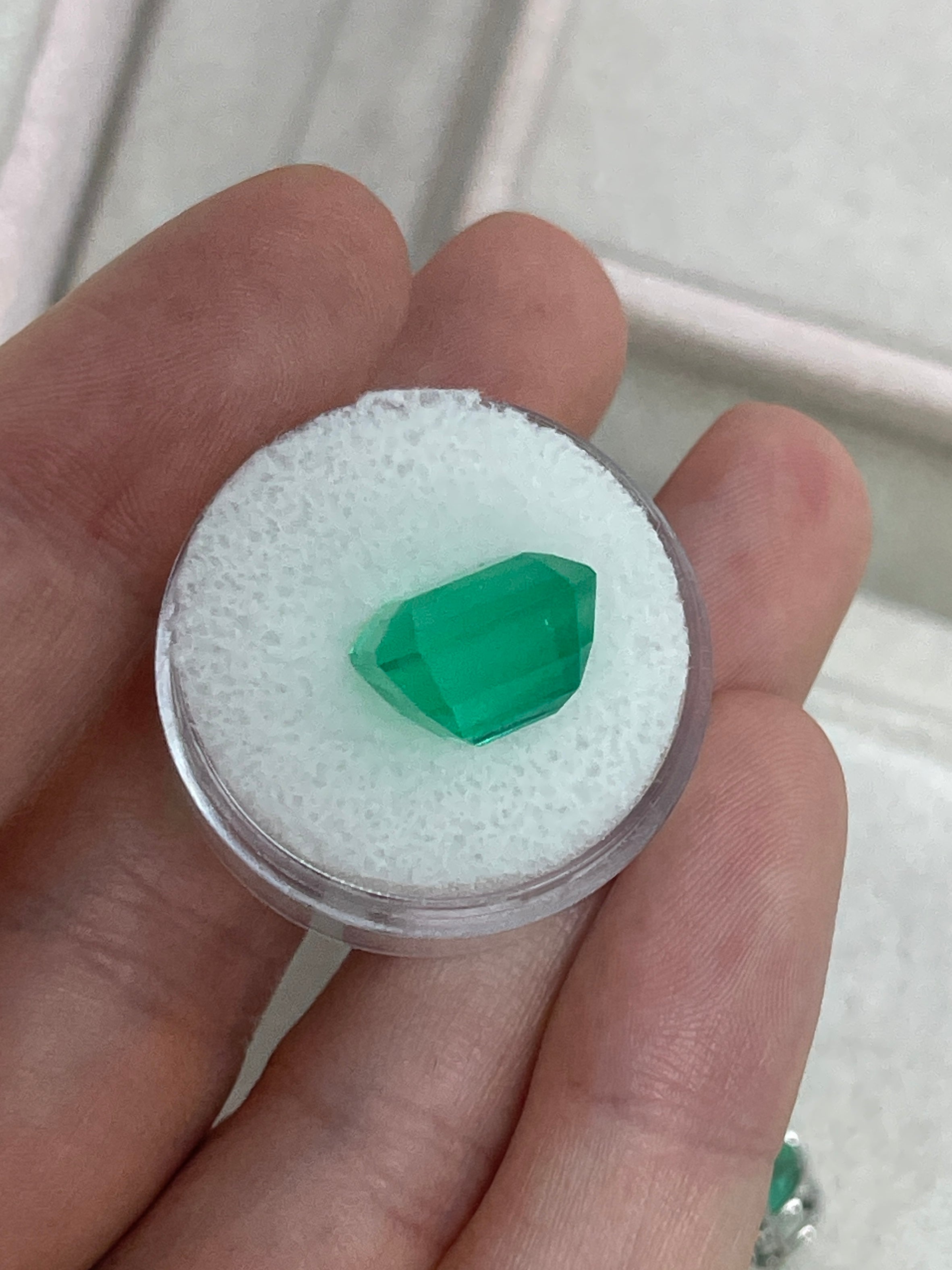 Vivid 8.98 carat Colombian emerald loose gemstone in 13x11 emerald cut, showcasing rich green color and clarity.