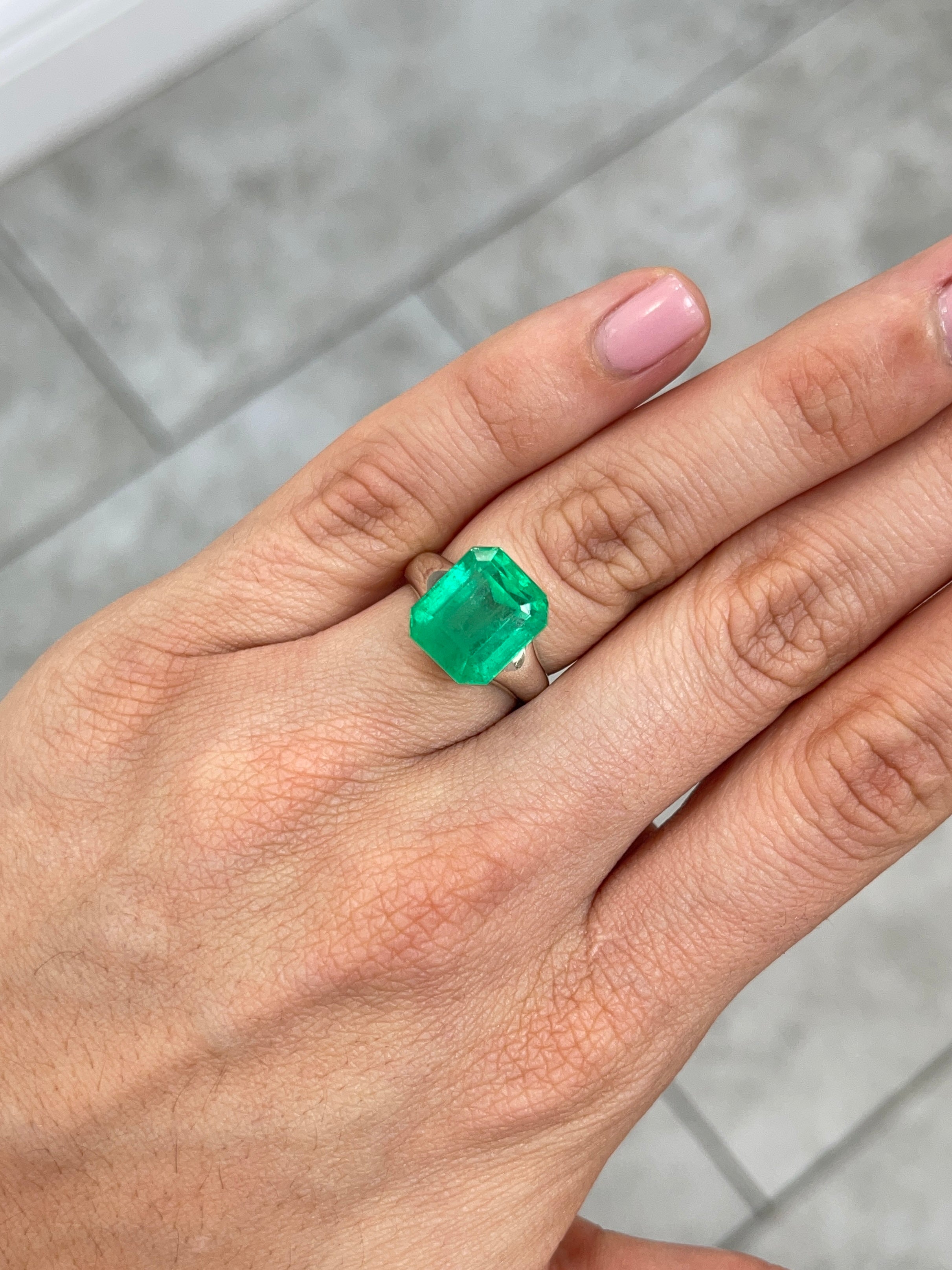 Vivid 8.98 carat Colombian emerald loose gemstone in 13x11 emerald cut, showcasing vibrant green color and clarity.