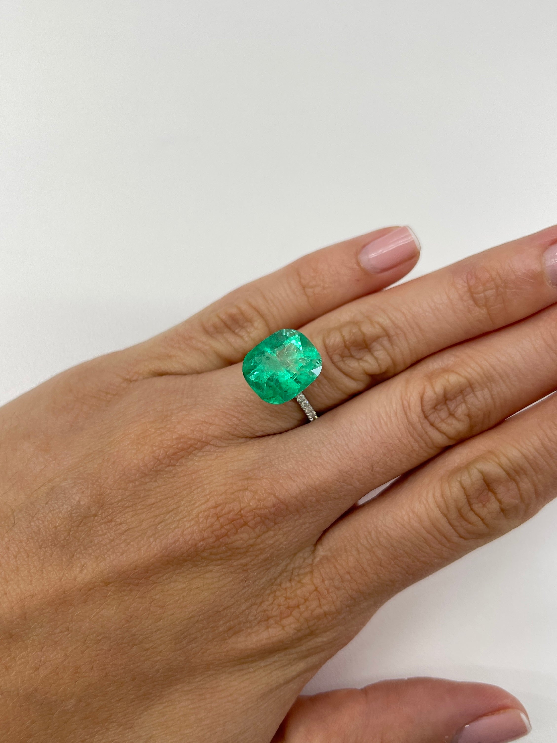 9.23 carat Muzo yellowish green Colombian emerald loose cushion cut gemstone with natural clarity and vibrant color.