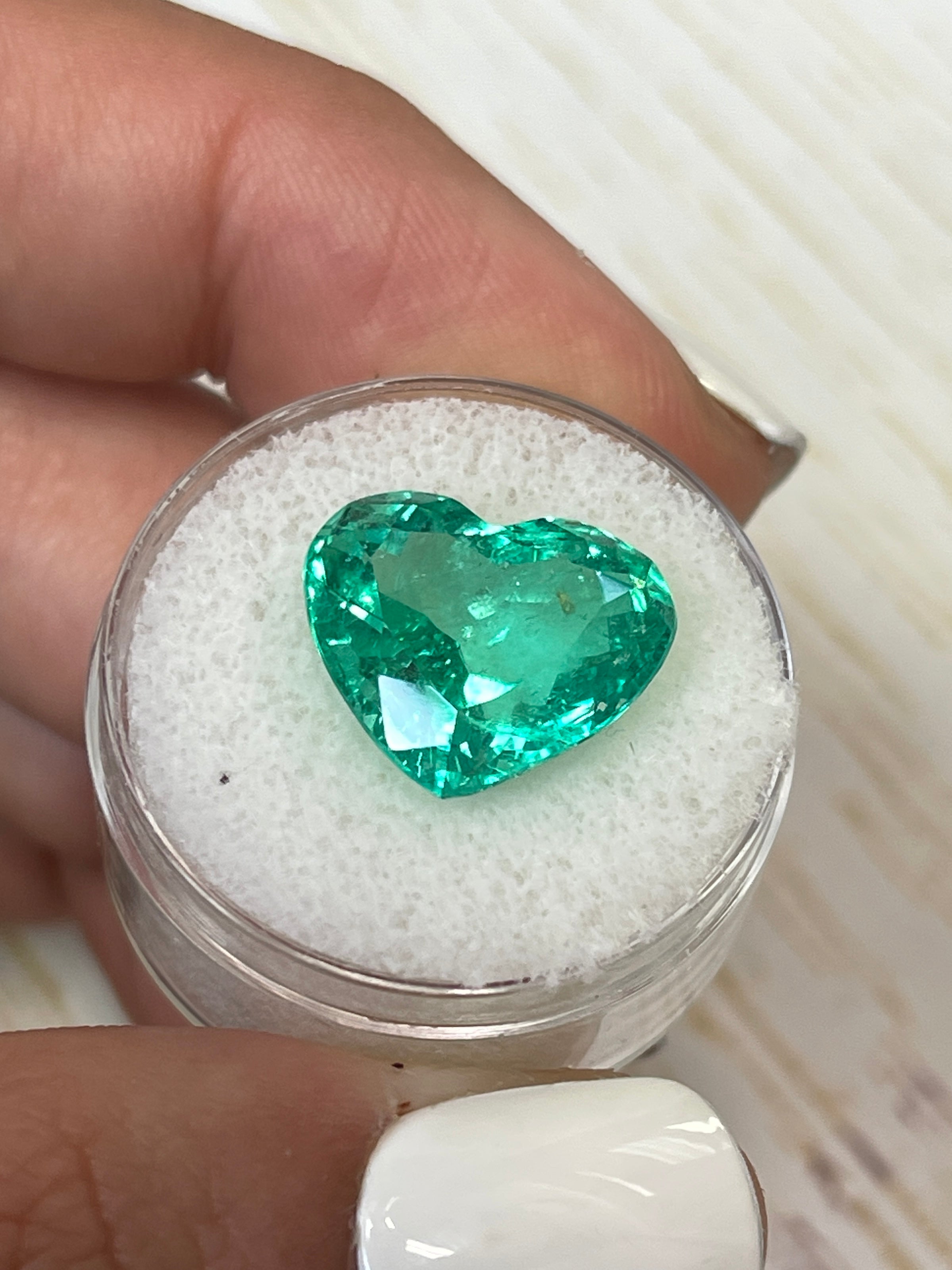 9.86 carat yellowish green natural Colombian emerald heart-shaped loose gemstone with 13x15mm cut, high transparency and vibrant color.