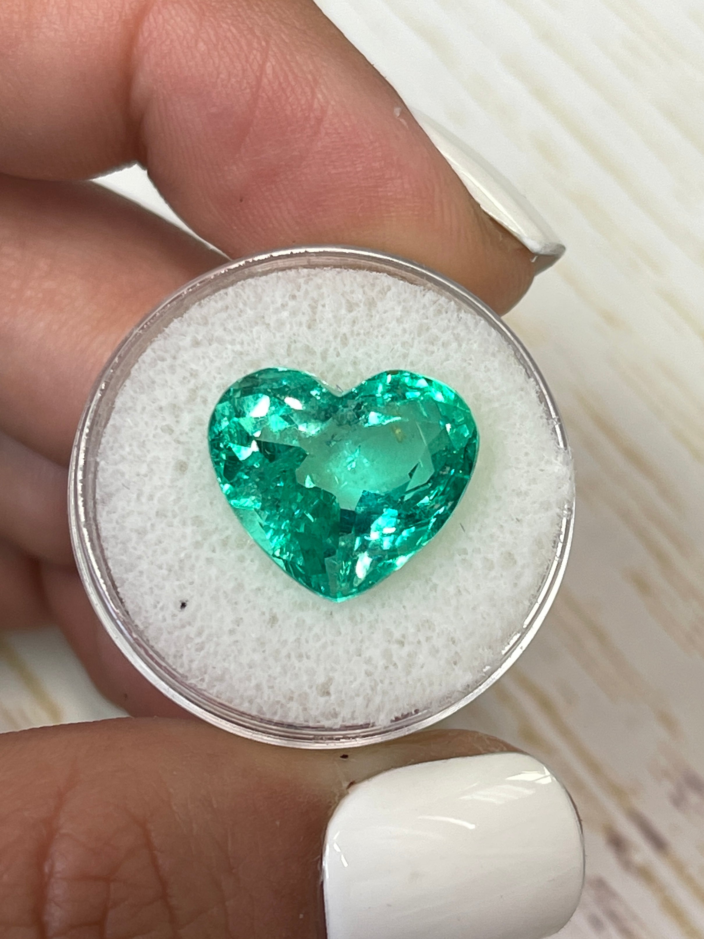 9.86 carat yellowish green natural Colombian emerald in heart cut, loose gemstone with vibrant color and clarity.
