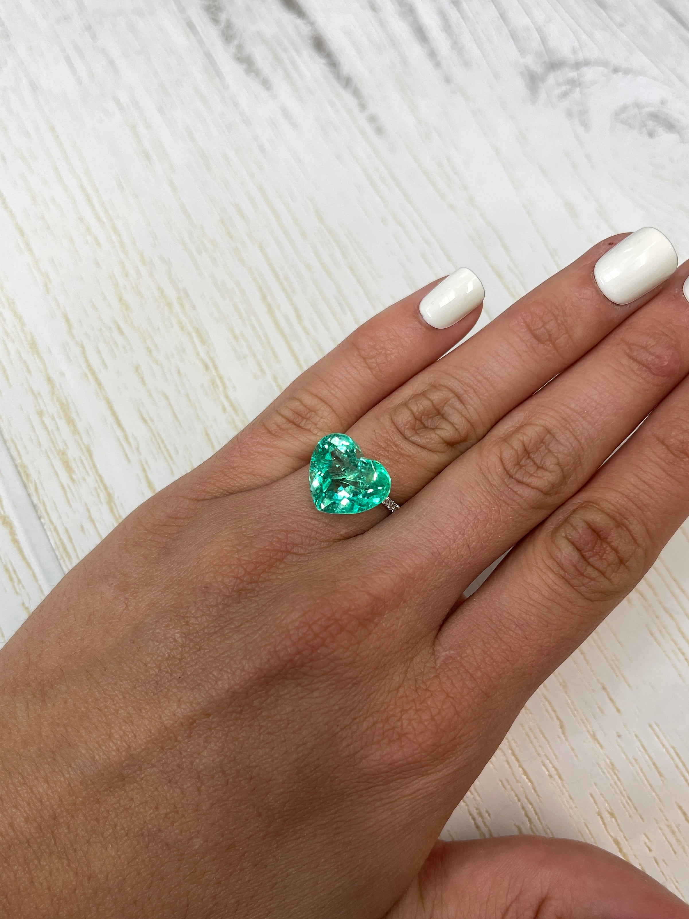 9.86 carat yellowish green natural Colombian emerald loose gemstone with heart cut, displayed by JR Colombian Emeralds