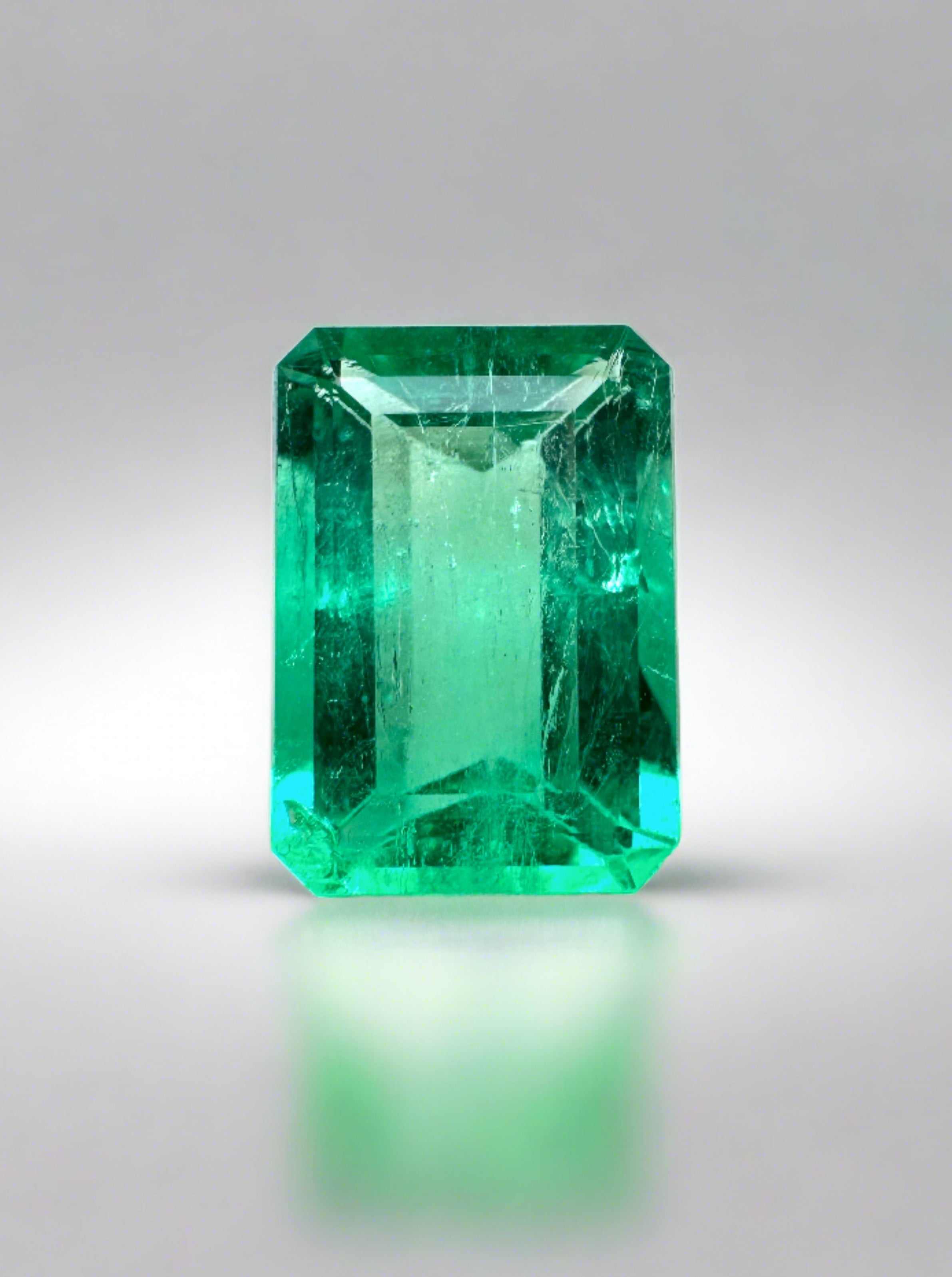 Natural 1.50 carat chromatic green Colombian emerald loose in emerald cut, displayed with lab diamond accents in a custom ring setting.