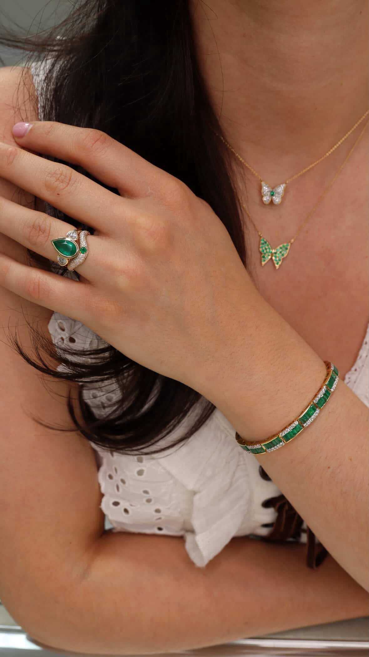 Custom curved emerald and diamond pave wedding band in 14K gold by JR Colombian Emeralds, size 7, with detailed gemstone settings.