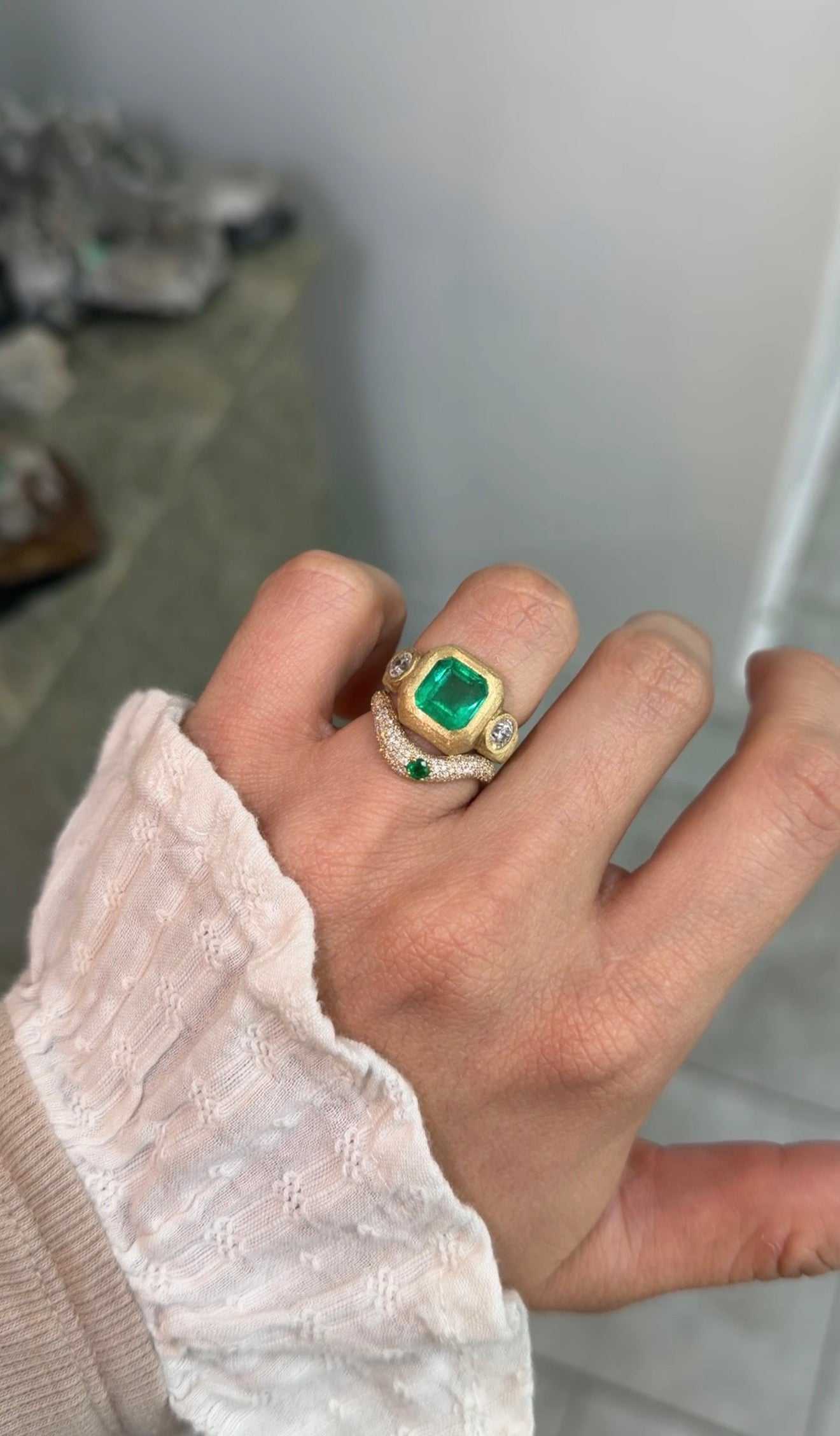 Custom curved emerald and diamond pave wedding band in 14K gold, size 7, featuring vibrant green emeralds and sparkling diamonds.