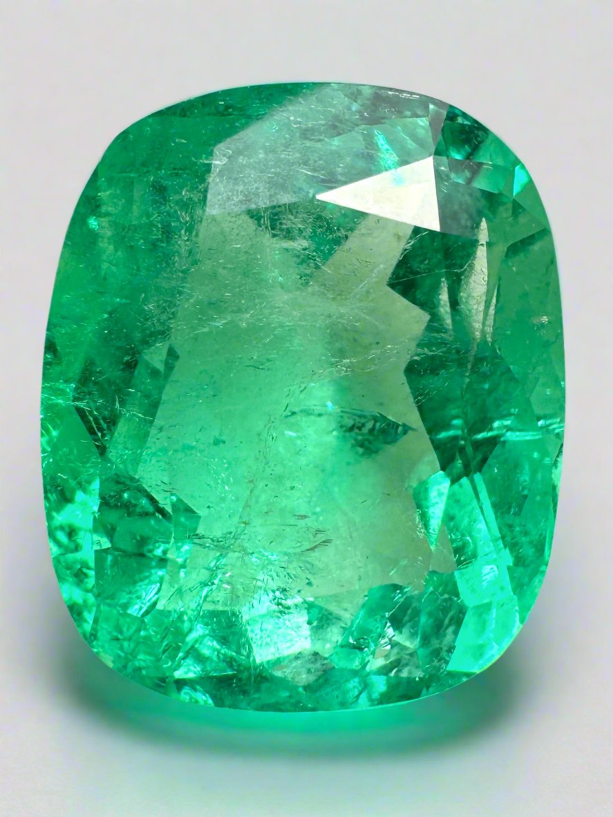 Large 11.50 carat yellowish Colombian Emerald cushion cut from JR Colombian Emeralds, showcasing vibrant green hue and natural clarity.