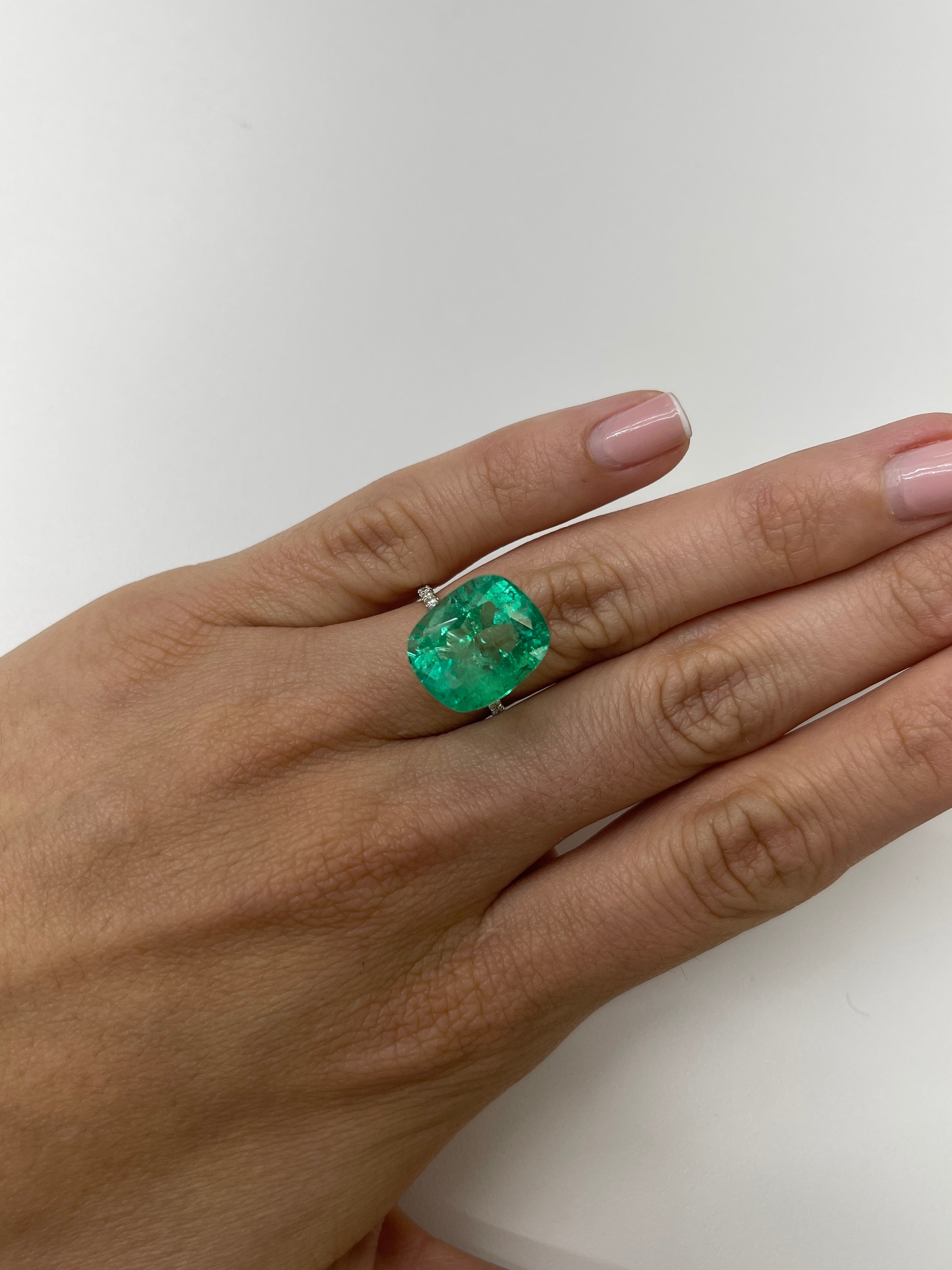 Large 11.50 carat yellowish natural cushion Colombian emerald from JR Colombian Emeralds with a 15.5x13 mm spready cut.