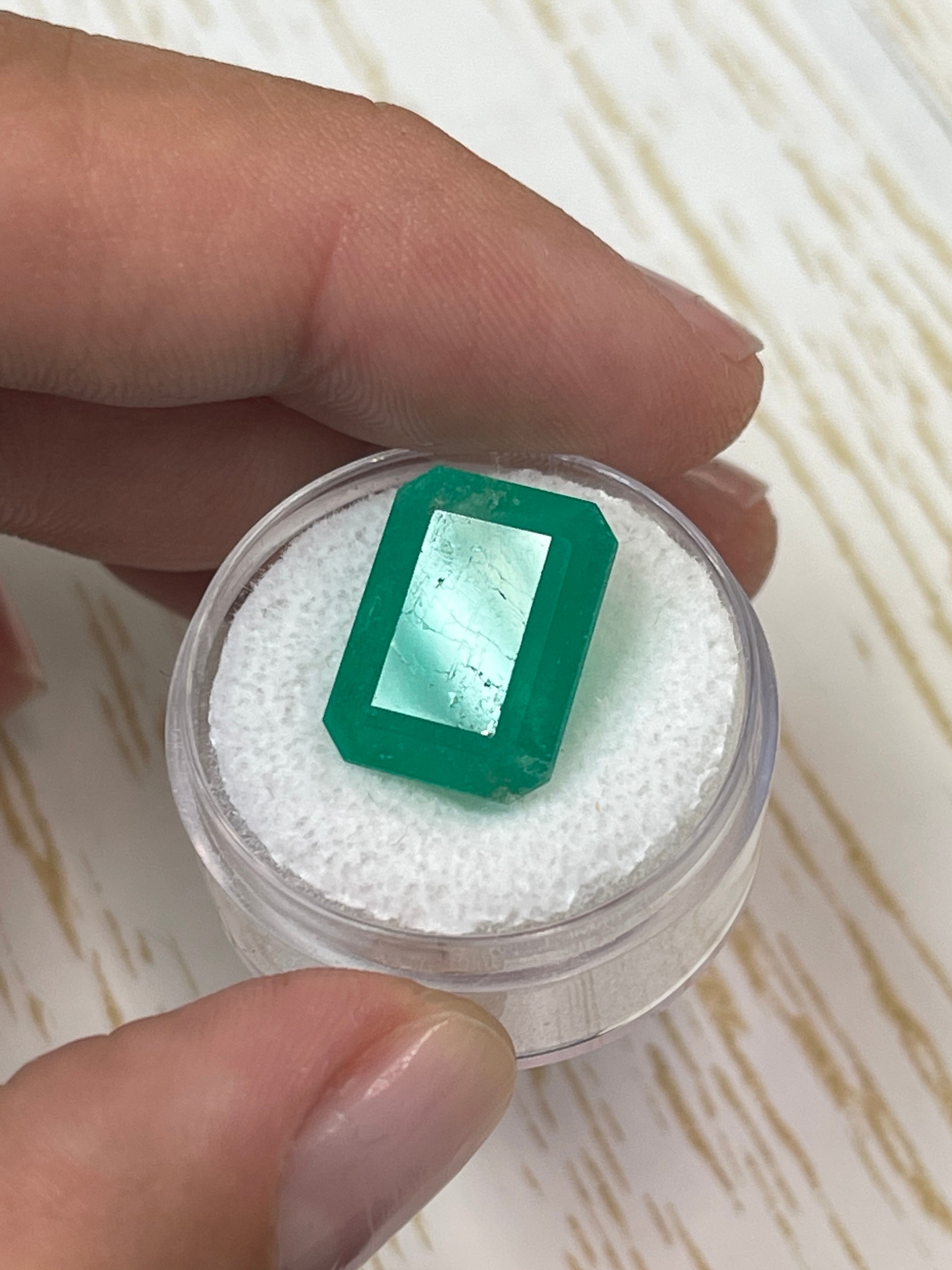 Large 12.13 carat natural Colombian emerald in an emerald cut, showcasing vibrant green color and clarity.