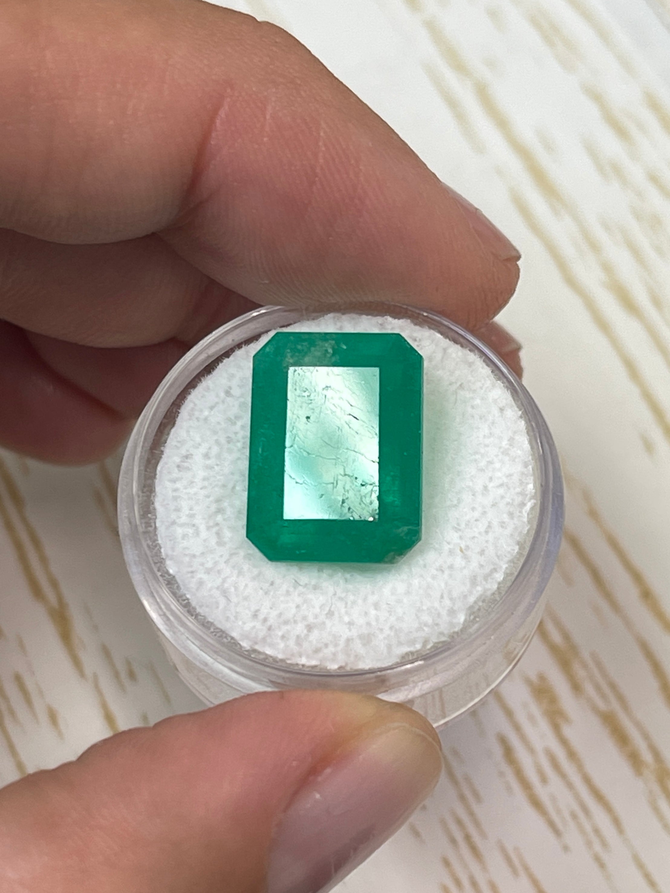 Large 12.13 carat natural Colombian emerald in an emerald cut, showcasing vibrant green color and clarity.