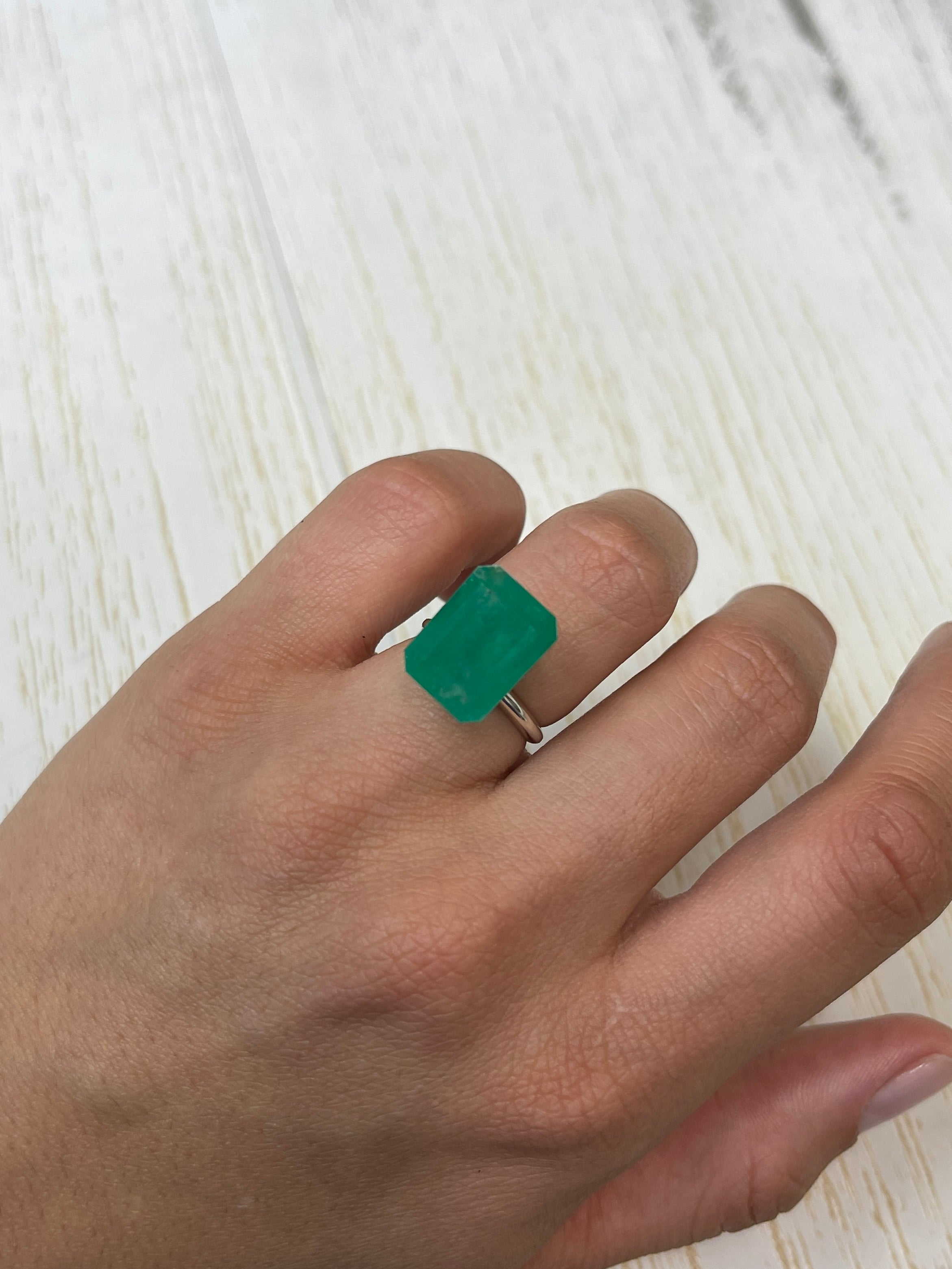 Large 12.13 carat natural Colombian emerald in an emerald cut, showcasing vibrant green color and clarity.