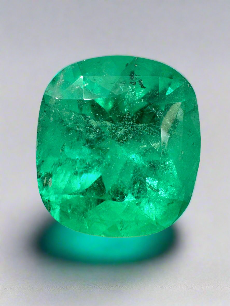 Large 12.27 carat Muzo yellowish green Colombian emerald, cushion cut, natural loose gemstone with vibrant color and clarity.