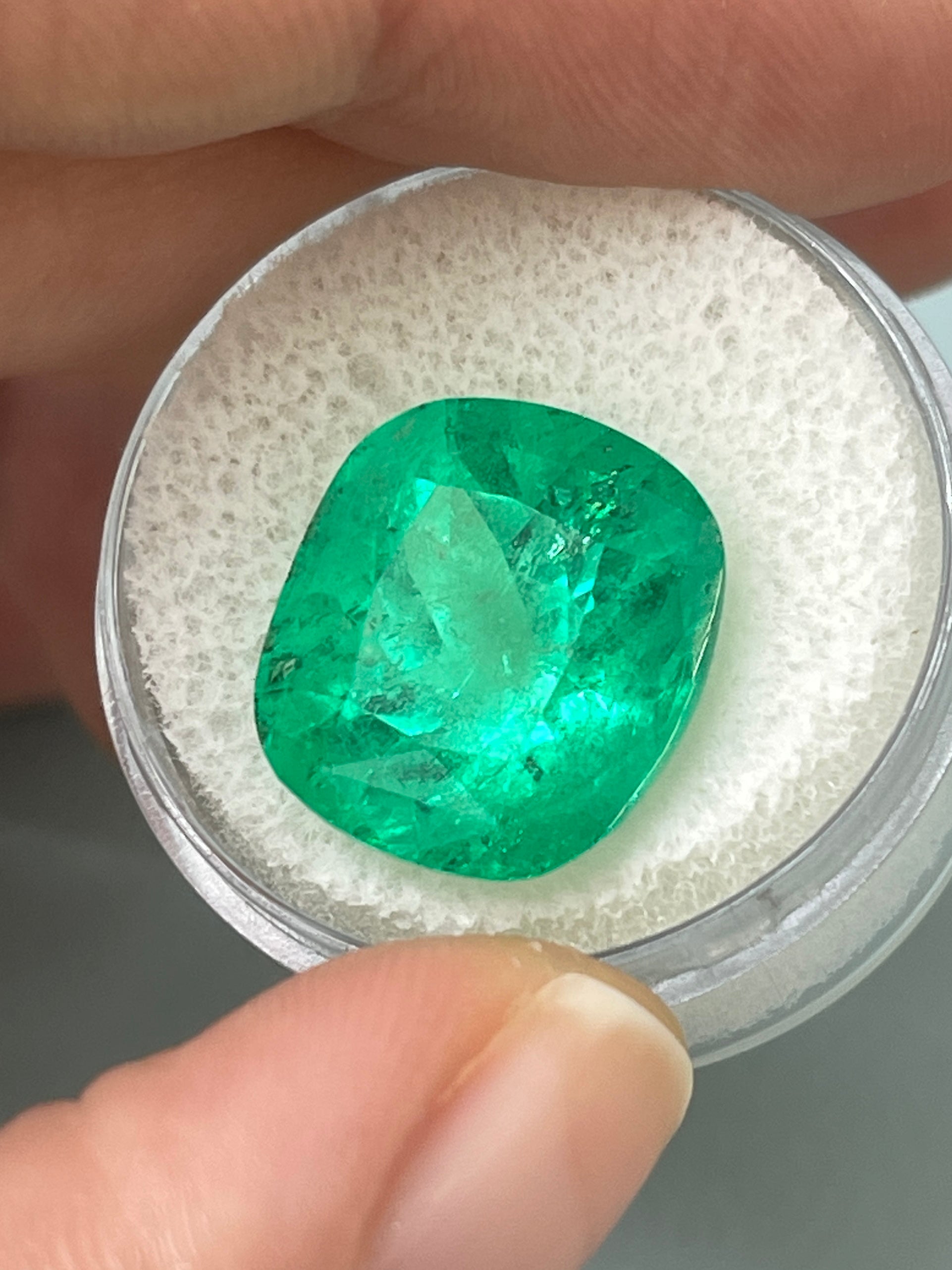Large 12.27 carat Muzo yellowish green Colombian emerald loose cushion cut gemstone with natural clarity.