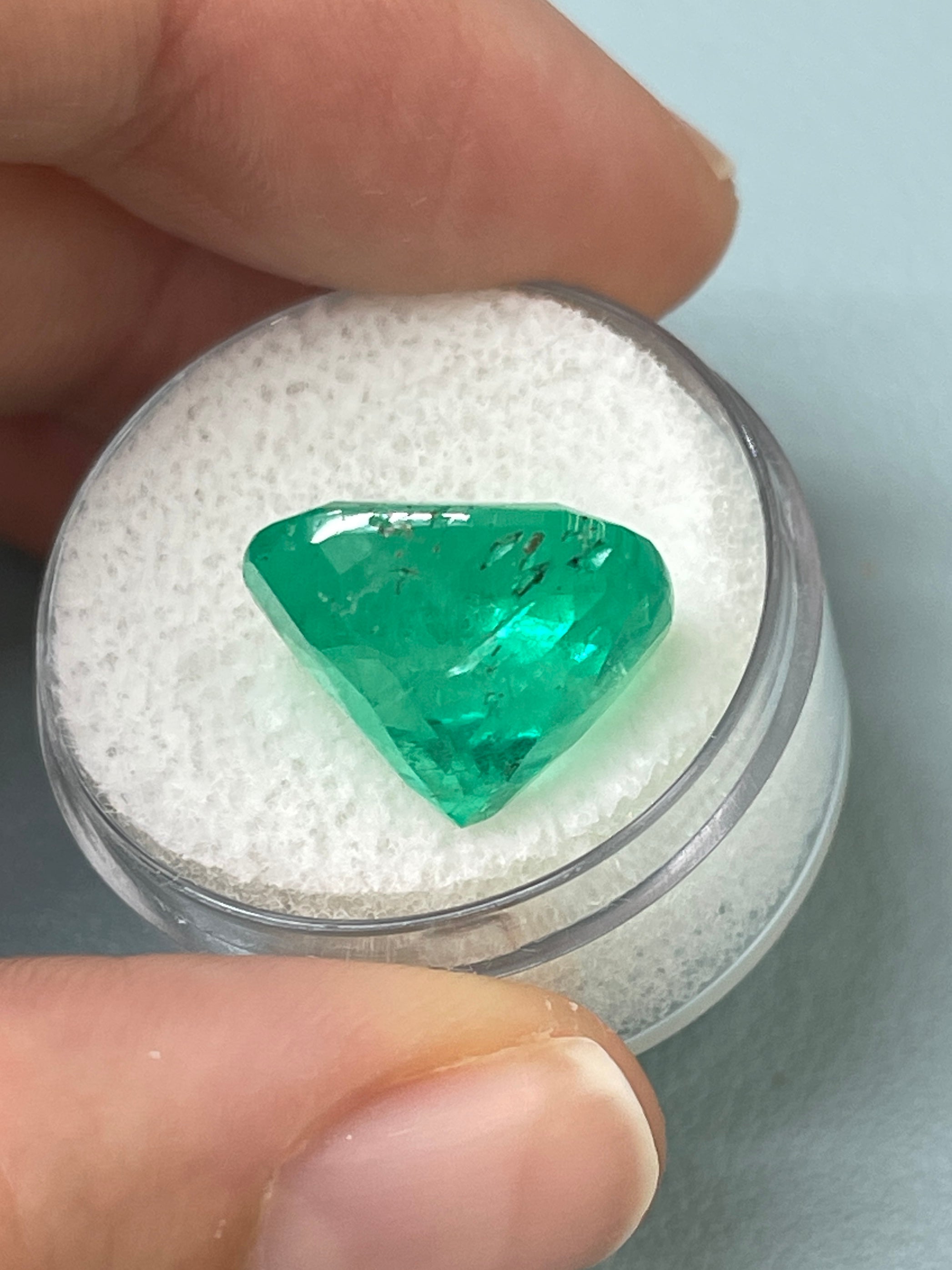 Large 12.27 carat Muzo yellowish green Colombian emerald cushion cut, natural loose gemstone with vibrant color and clarity.