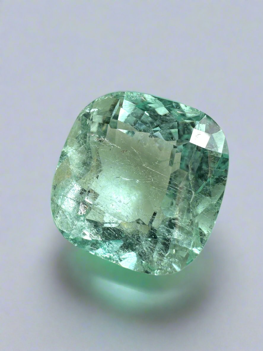 Large 12.86-carat natural cushion Colombian emerald from JR Colombian Emeralds, showcasing vibrant green color and clarity.