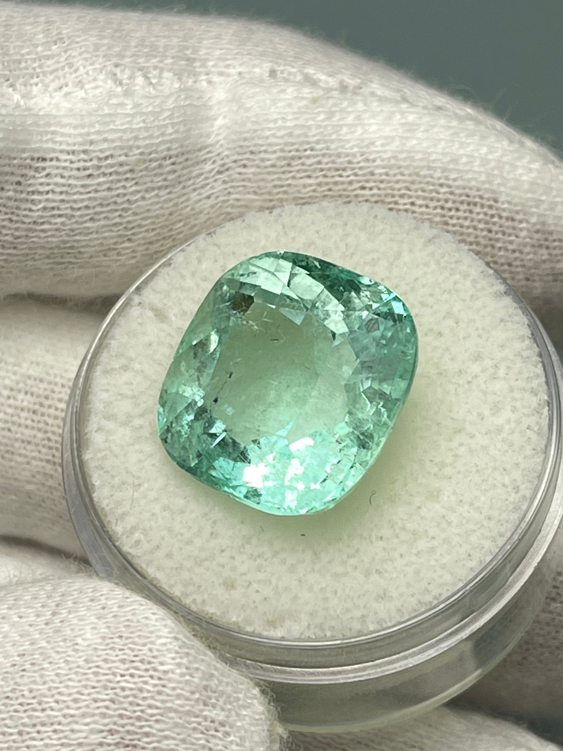 Large 12.86 carat natural cushion-cut Colombian emerald from JR Colombian Emeralds, vibrant green gemstone with a rich, lush hue.