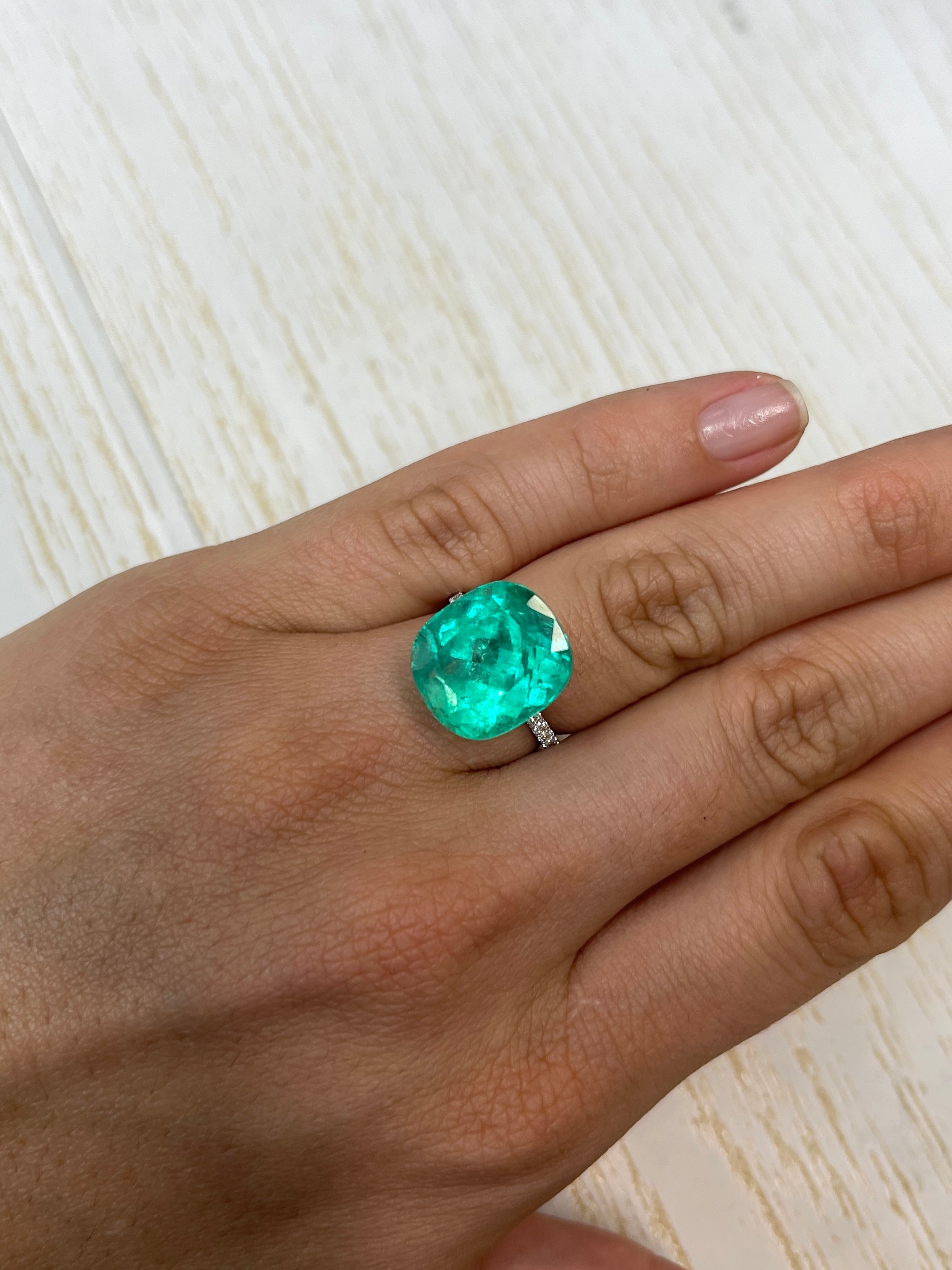 Large 14.44 carat bluish green Colombian emerald loose cushion cut gemstone with minor oil treatment, natural and radiant.