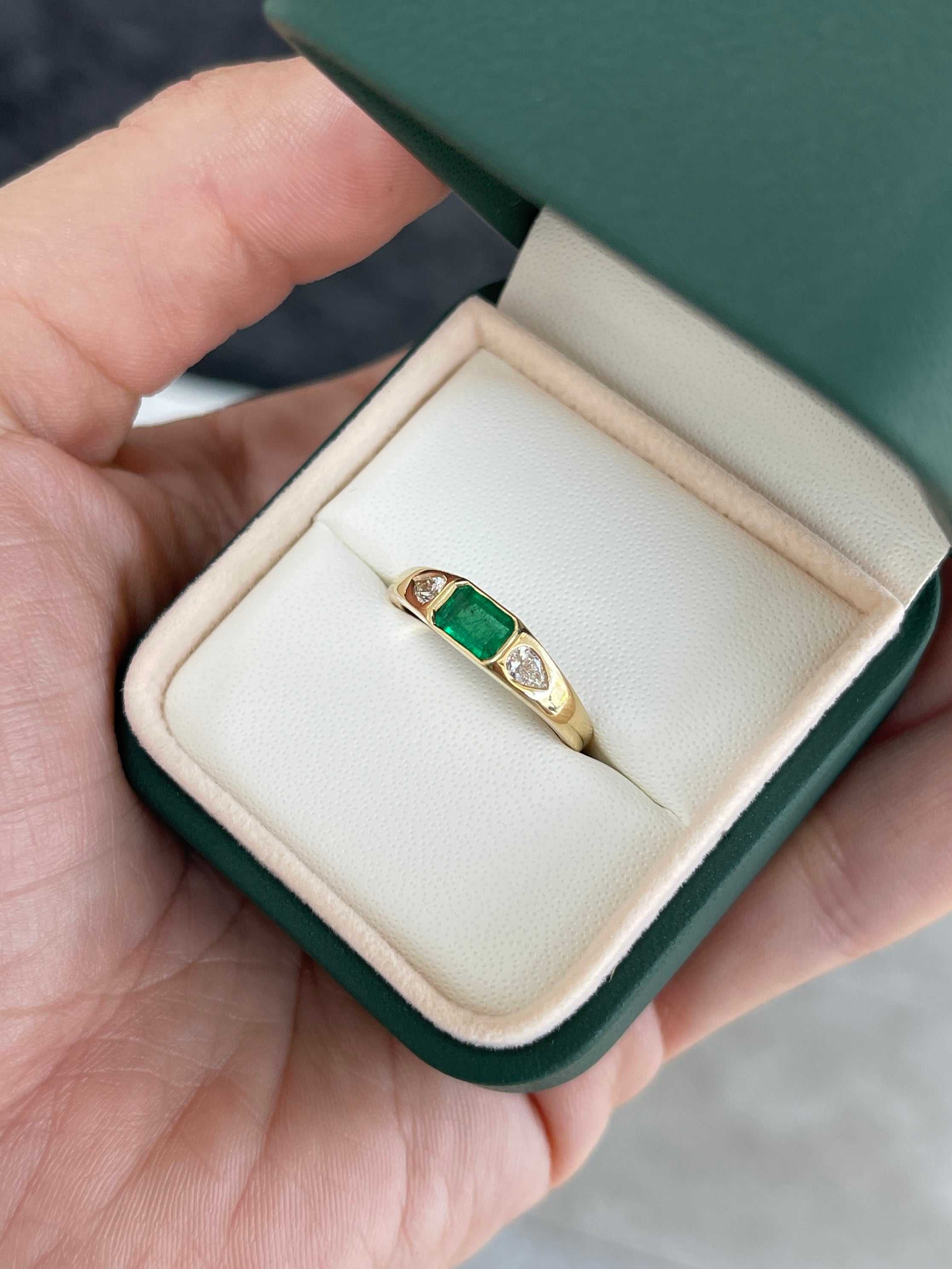 18K gold three-stone ring featuring a 0.91-carat rich green natural emerald and pear-shaped diamonds, by JR Colombian Emeralds.