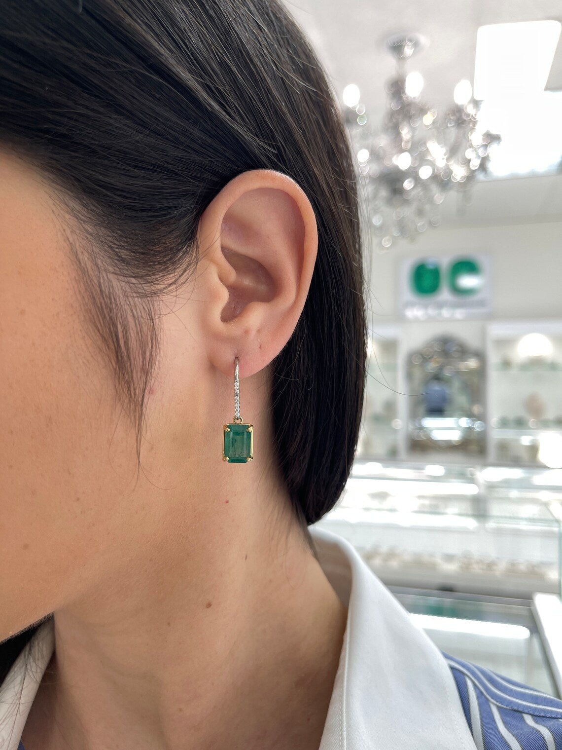 JR Colombian Emeralds earrings with 8.32 carats of emerald dangle features and diamond accents, with leverback hooks.