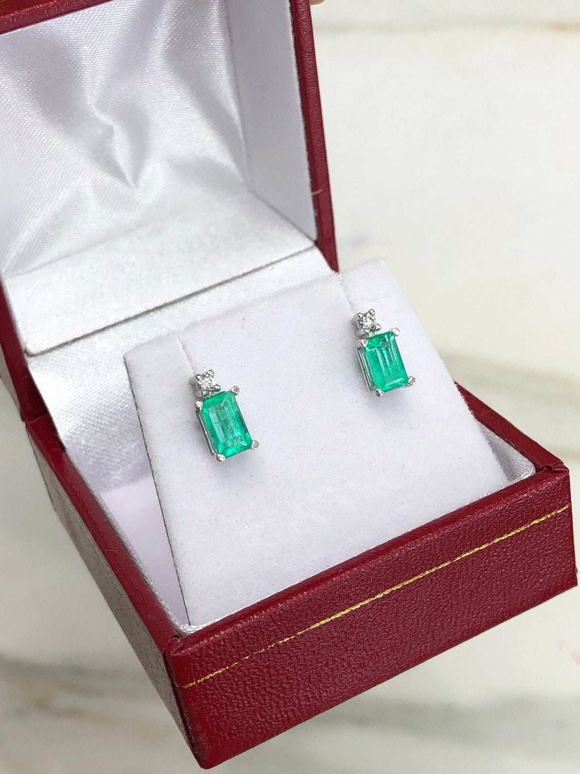 JR Colombian Emeralds 14K gold stud earrings with 1.56 carats of earth-mined emeralds and diamonds, displayed on a white background.
