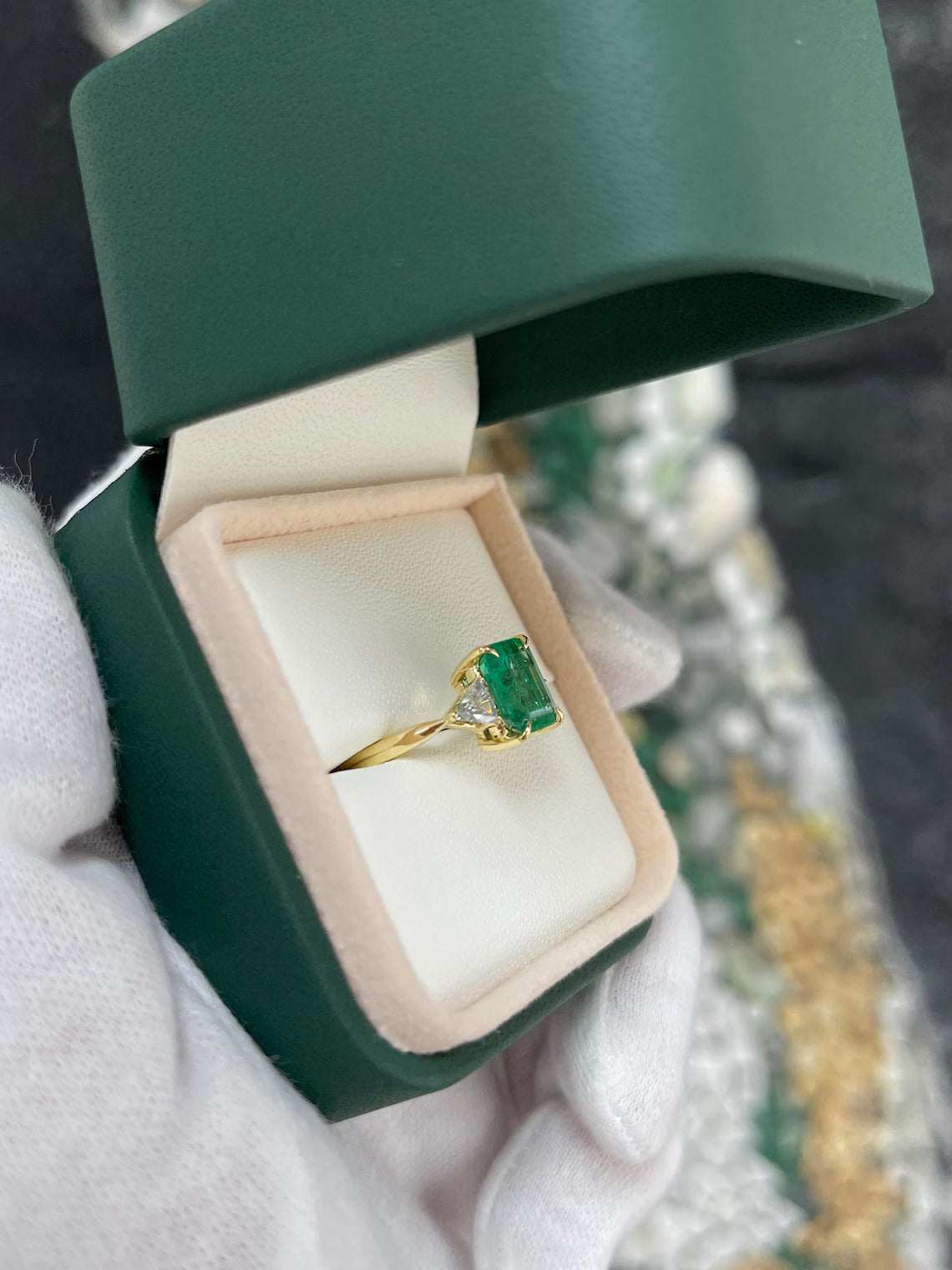 2.37 Carat Emerald Cut Emerald Features Trillion Diamond Side Stones