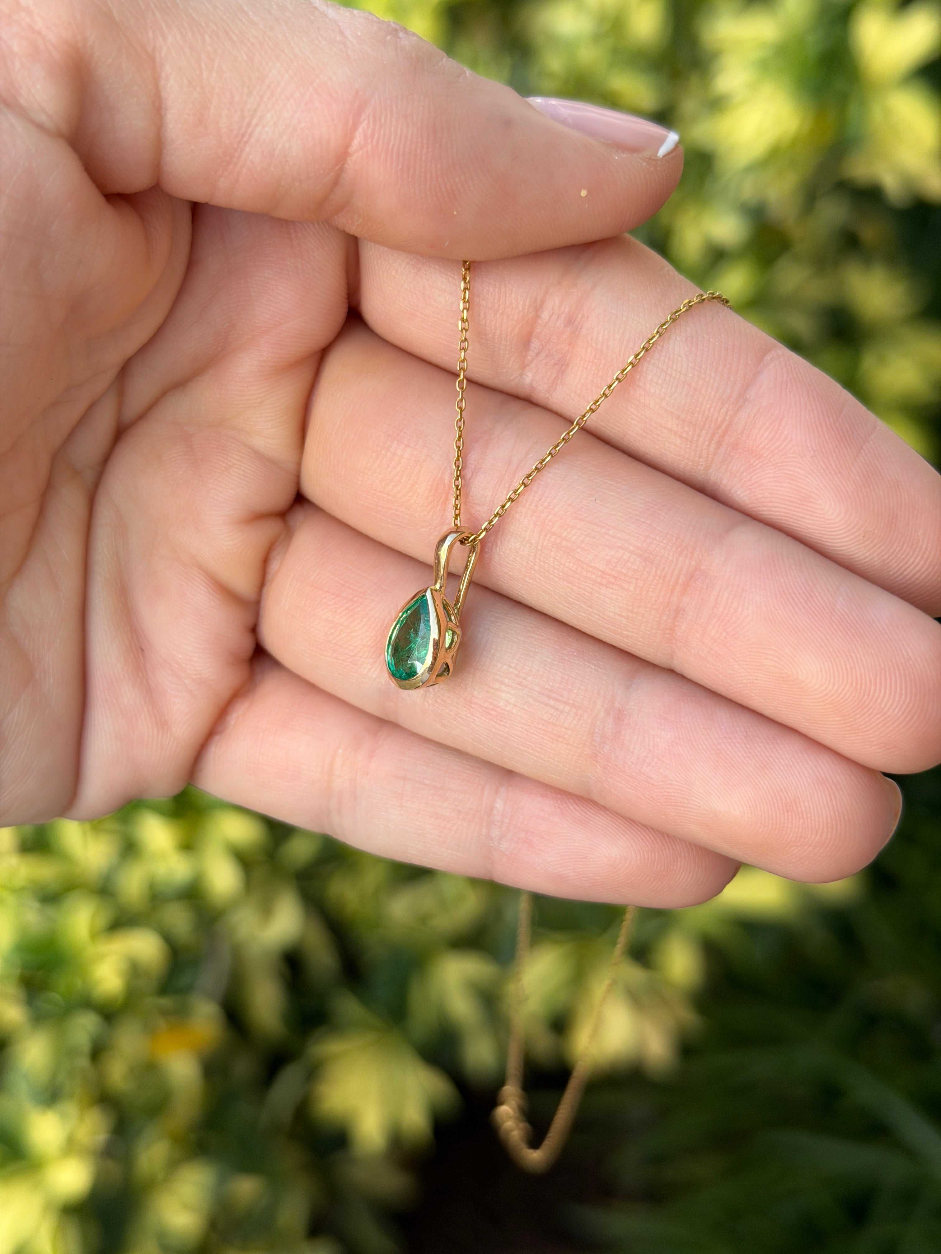 Helena 1.0ct bezel set natural emerald pear necklace by JR Colombian Emeralds, featuring a 14K gold chain and pendant.