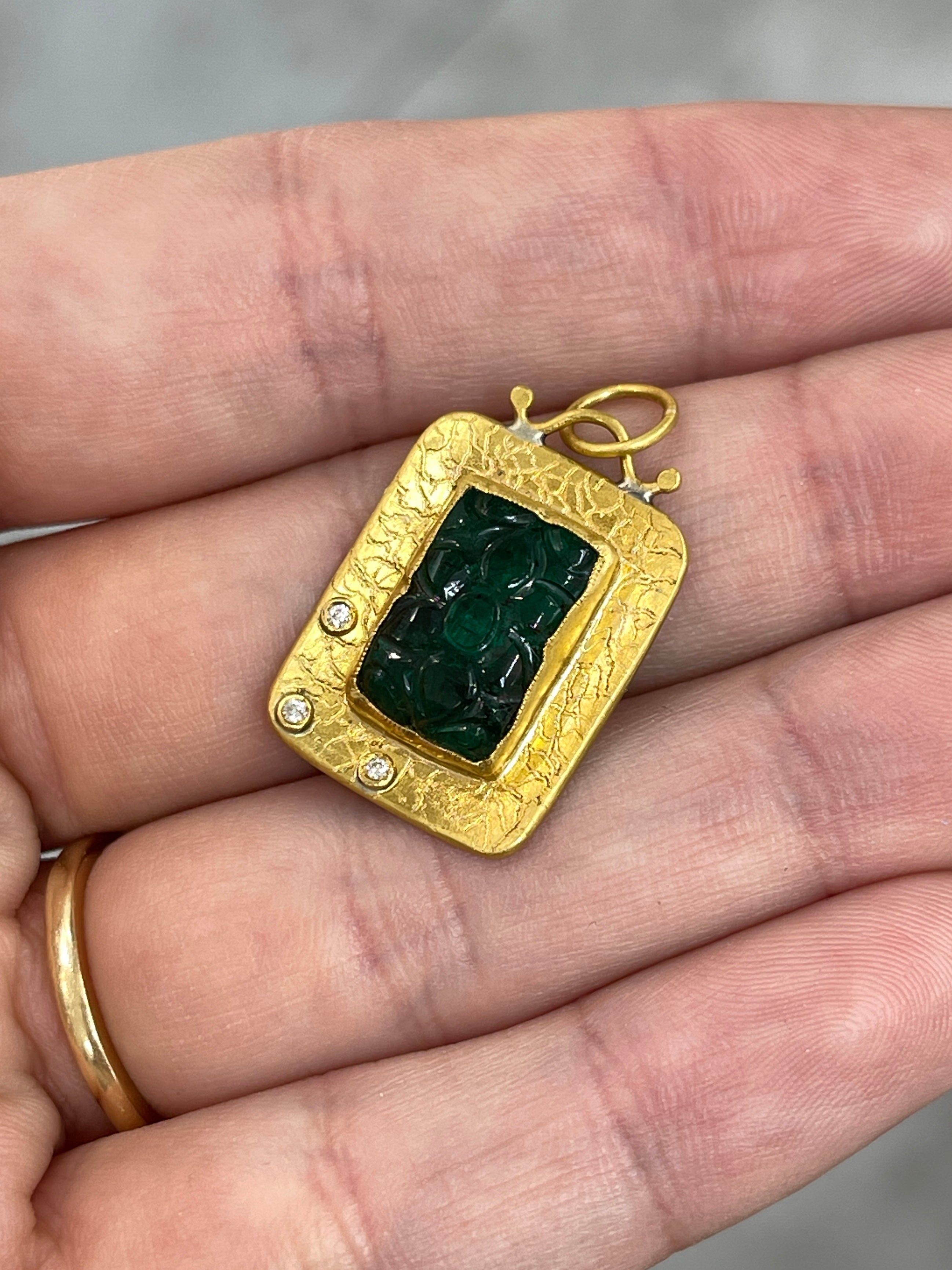 Hand-carved floral emerald and diamond pendant in 24K gold by JR Colombian Emeralds, highlighting intricate design and vibrant colors.