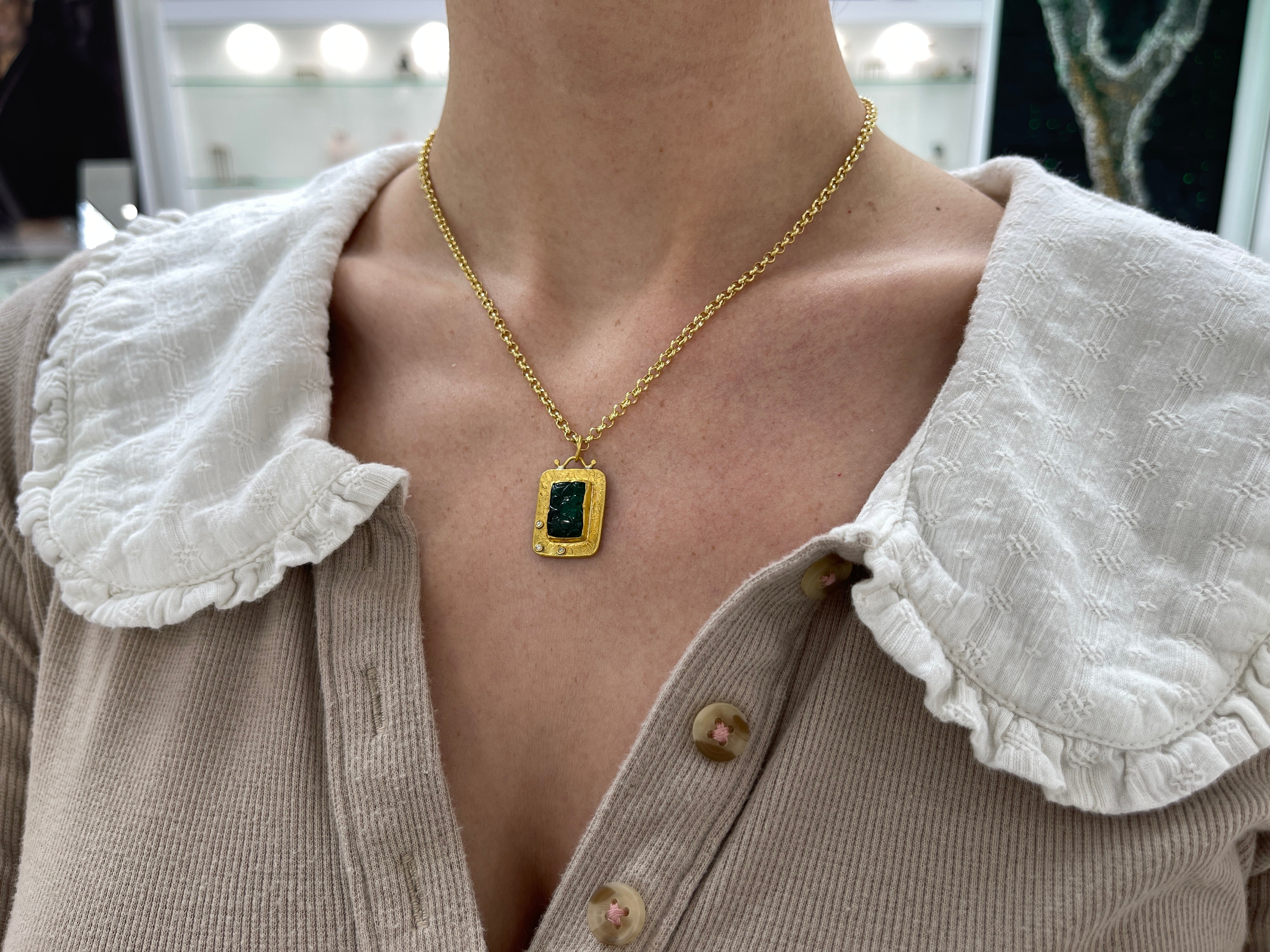 Floral hand-carved emerald and diamond pendant in 24K gold by JR Colombian Emeralds, showcasing intricate design and vibrant colors.