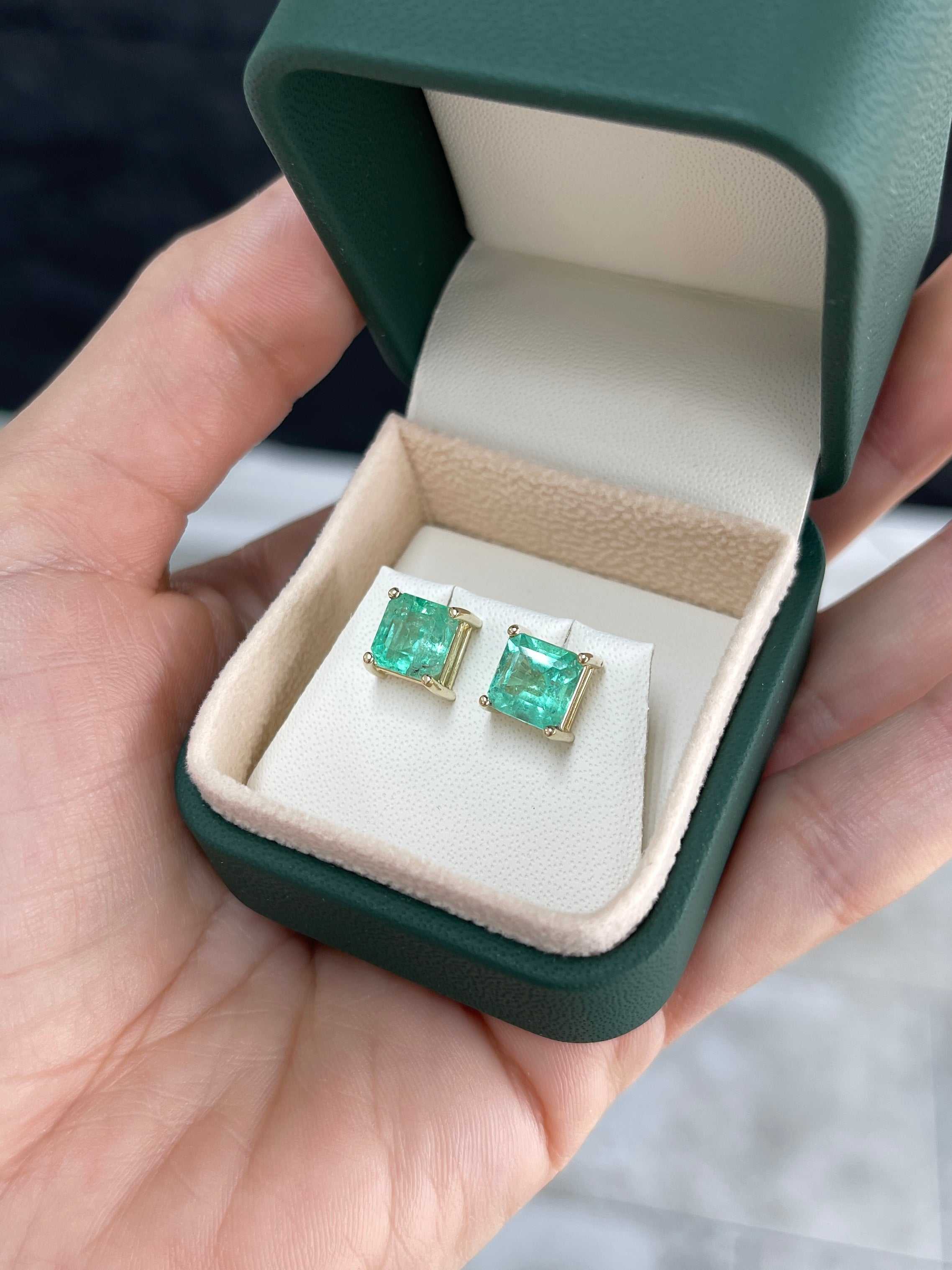 Asscher cut Colombian emerald stud earrings featuring 3.97tcw earthy-spring green gemstones set in 14K gold.