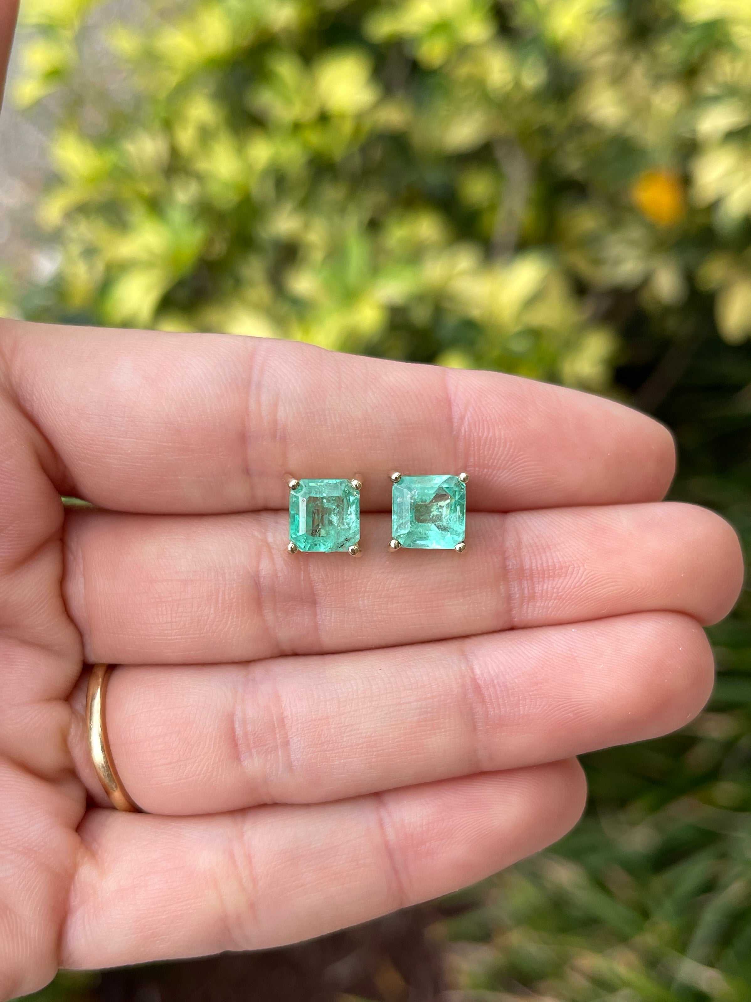 Asscher cut Colombian emerald stud earrings with 3.97tcw earthy-spring green gemstones set in 14K gold.
