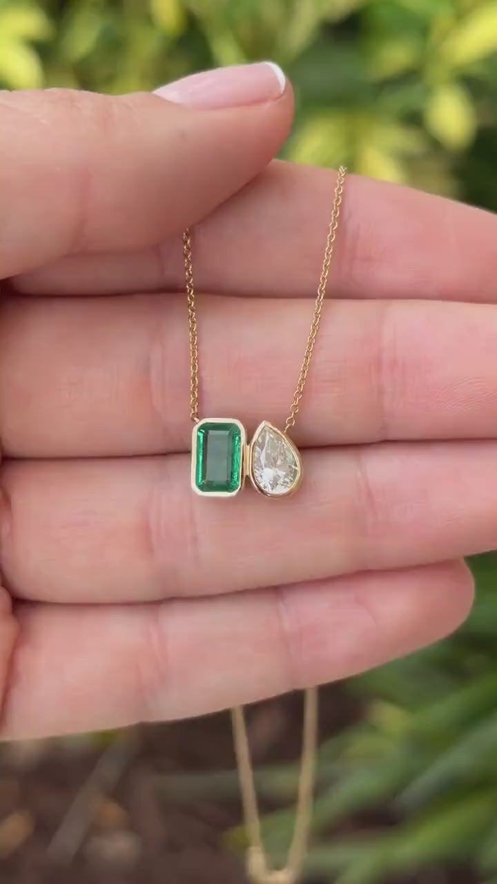 Emerald moissanite toi et moi pendant necklace with 14K yellow gold setting  showcasing two sparkling gemstones, by JR Colombian Emeralds